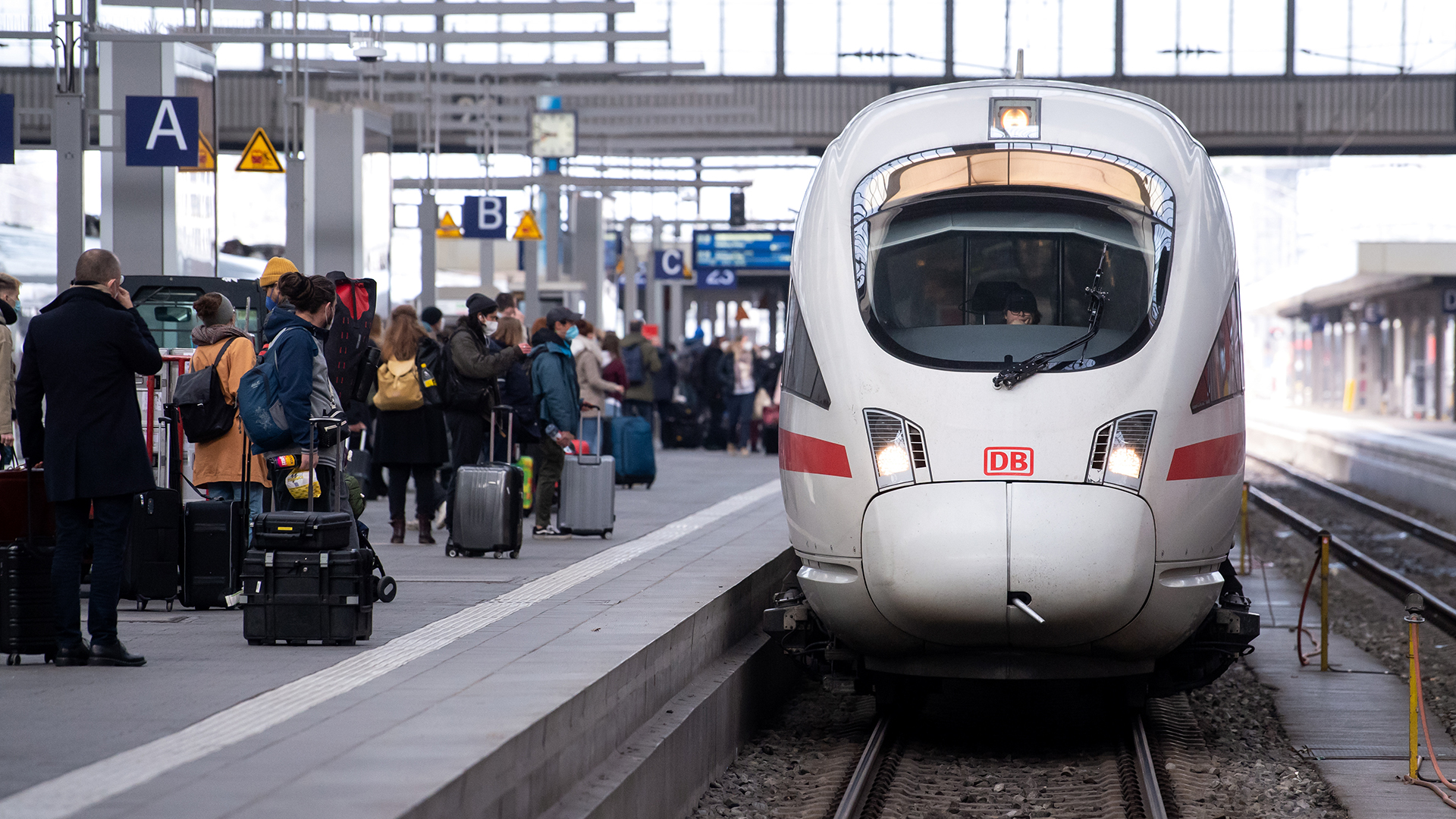 Reisende stehen neben einem ICE auf einem Bahnsteig am Hauptbahnhof in München. | dpa