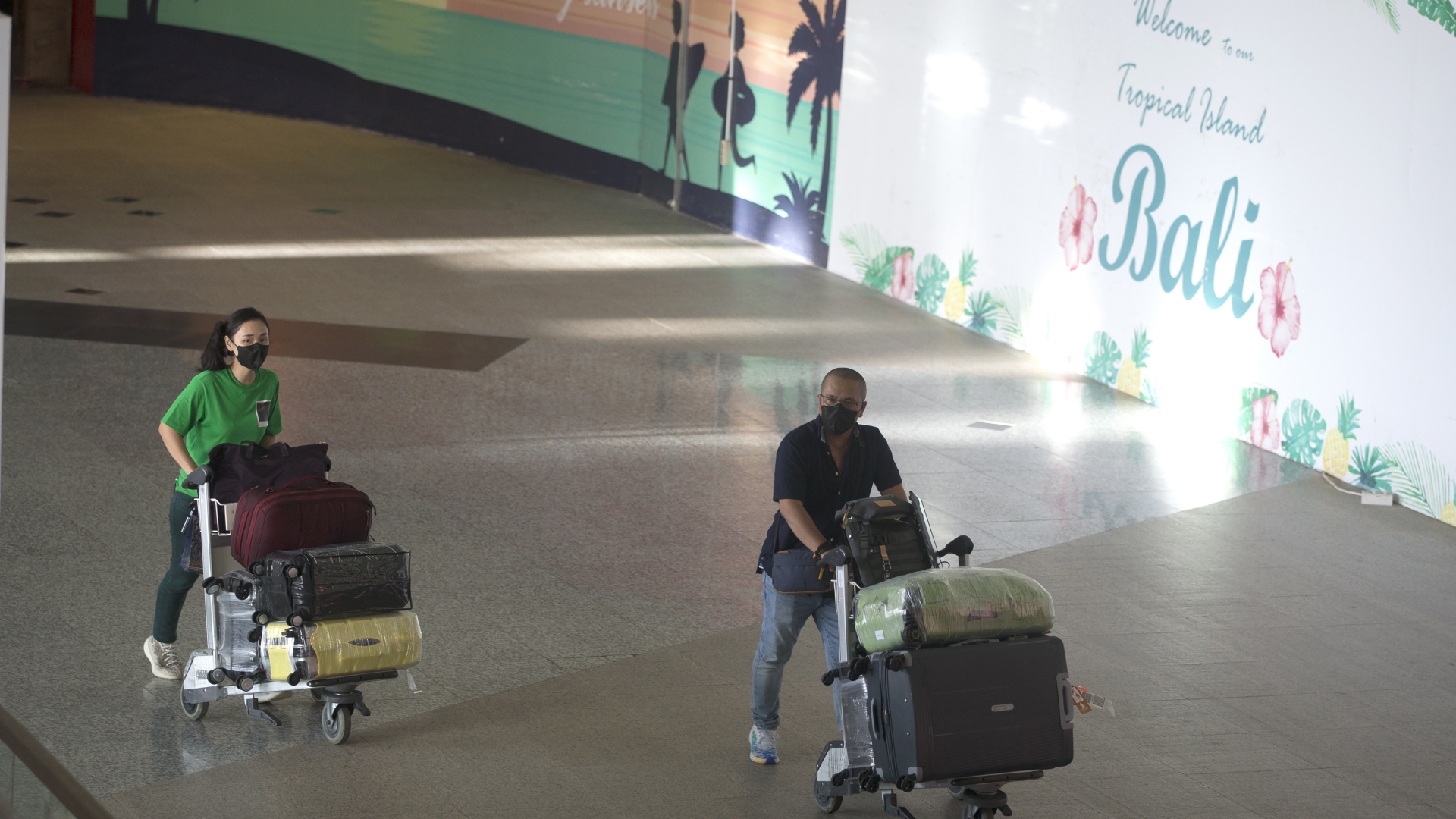 Touristen schieben Gepäckstücke auf dem internationalen Flughafen von Bali | dpa