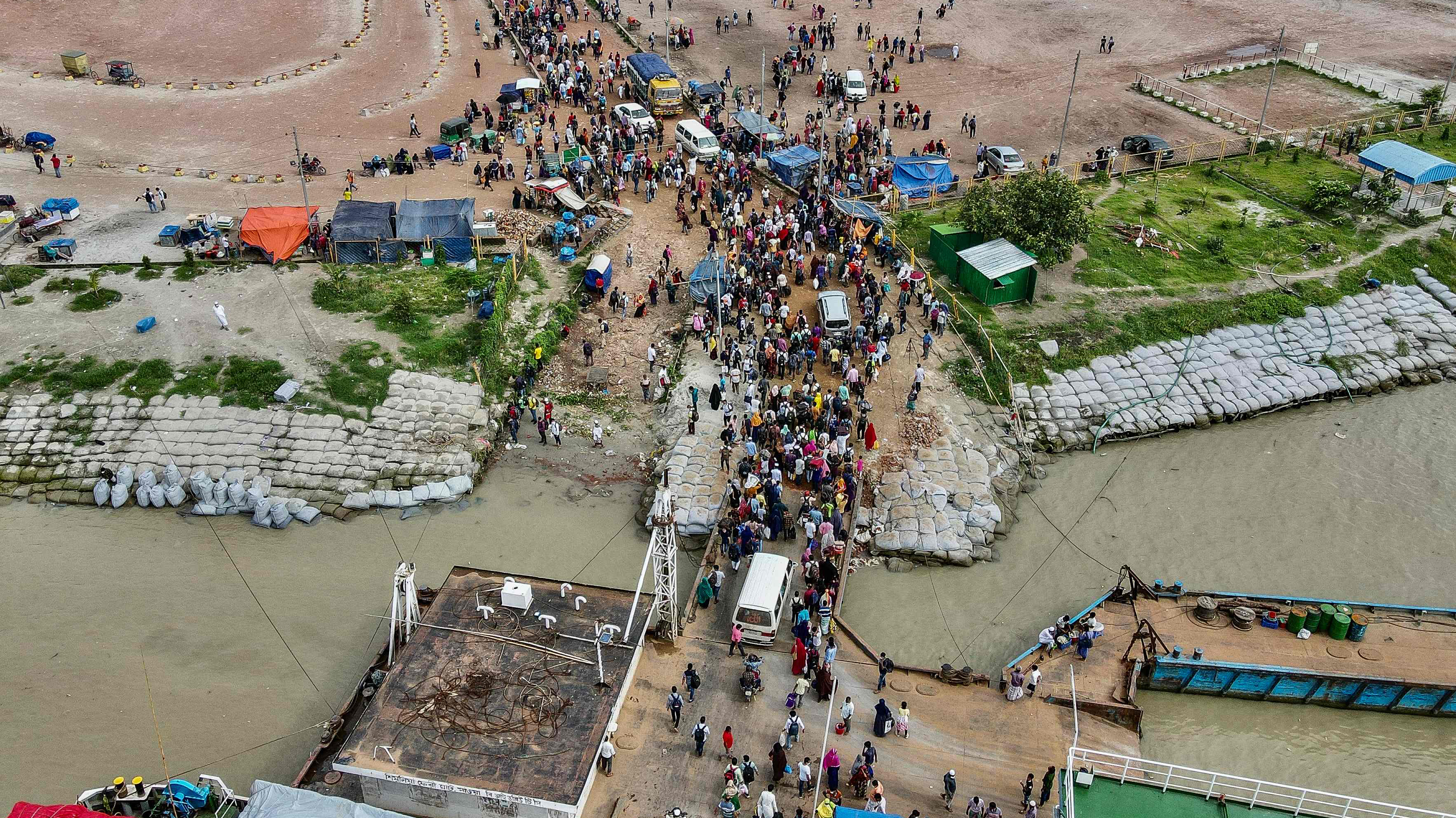 Menschen in Bangladesh kommen von einer Fähre aufs Festland, um wieder an ihre Arbeitsplätze zurückzukehren. | AFP