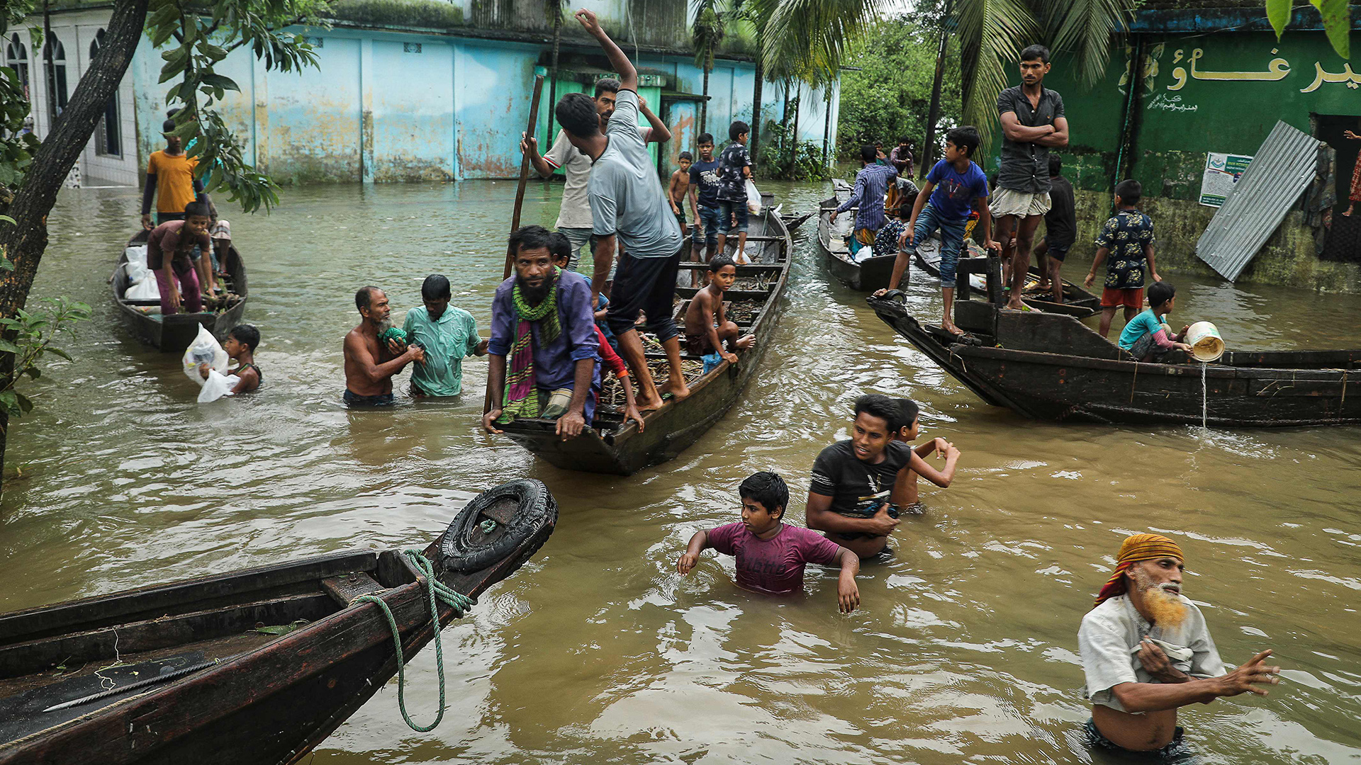 Menschen vim Wasser und in Booten in einem überfluteten Wohngebiet in Companiganj, Bangladesh | AFP