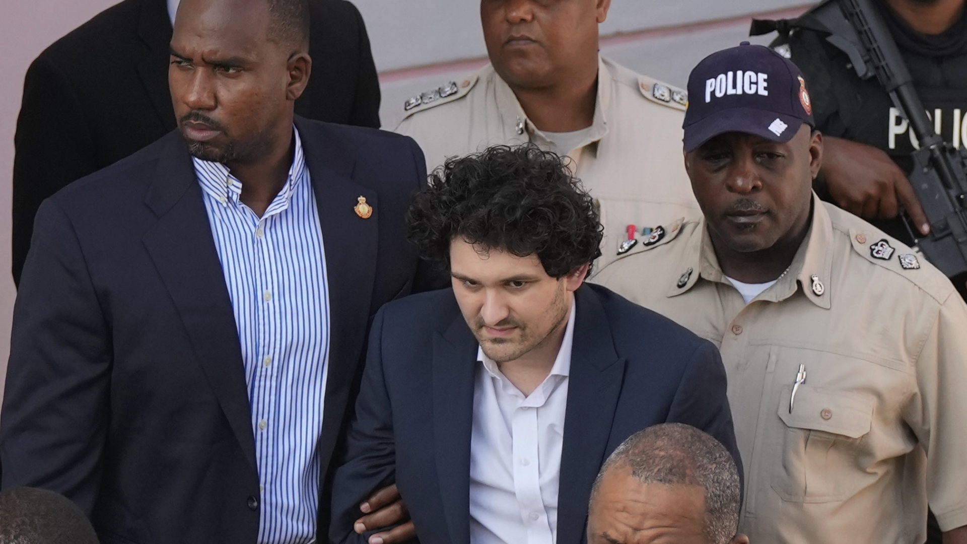 FTX-Gründer Sam Bankman-Fried (Mitte) wird nach einer Anhörung in Nassau, Bahamas, aus dem Gericht in einen Gefangenentransporter eskortiert. | AP