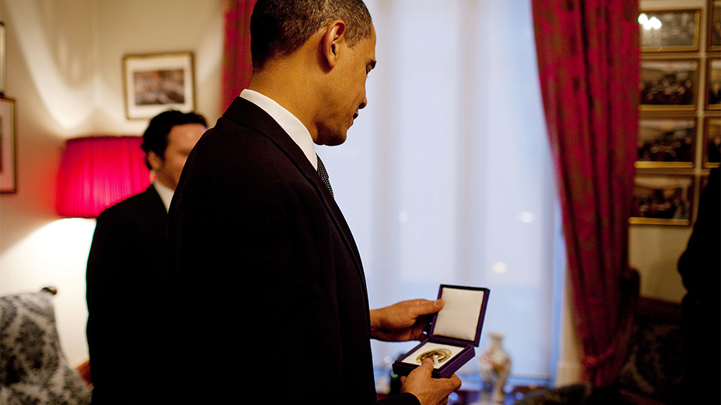 Barack Obama hält die Medaille des Friedensnobelpreises in den Händen | picture alliance / dpa