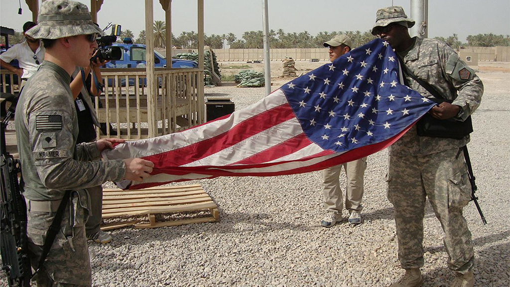 US-amerikanische Soldaten falten eine Flagge zusammen  | picture alliance / dpa