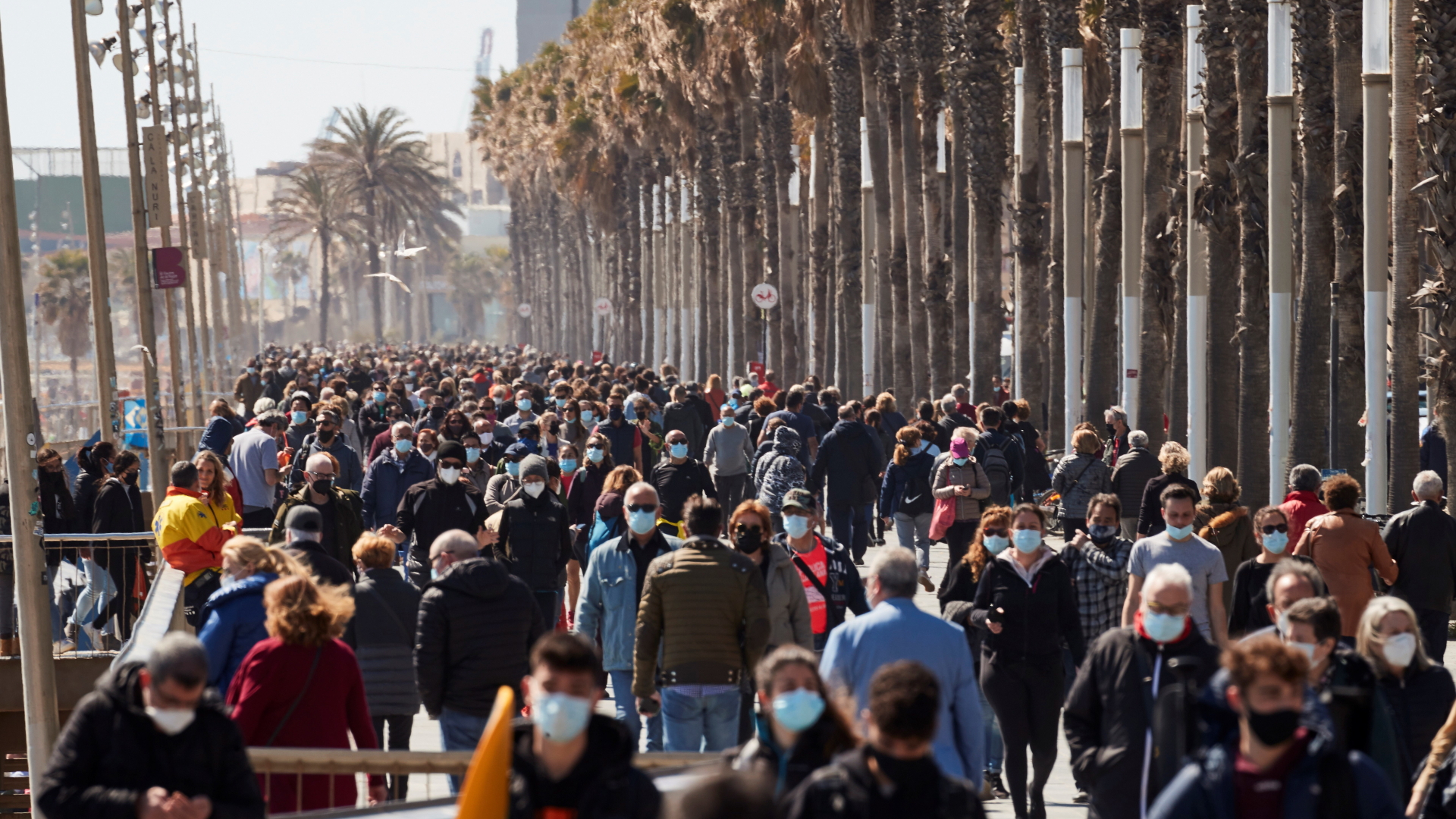 Menschen auf einer Strandpromenade in Barcelona | EPA