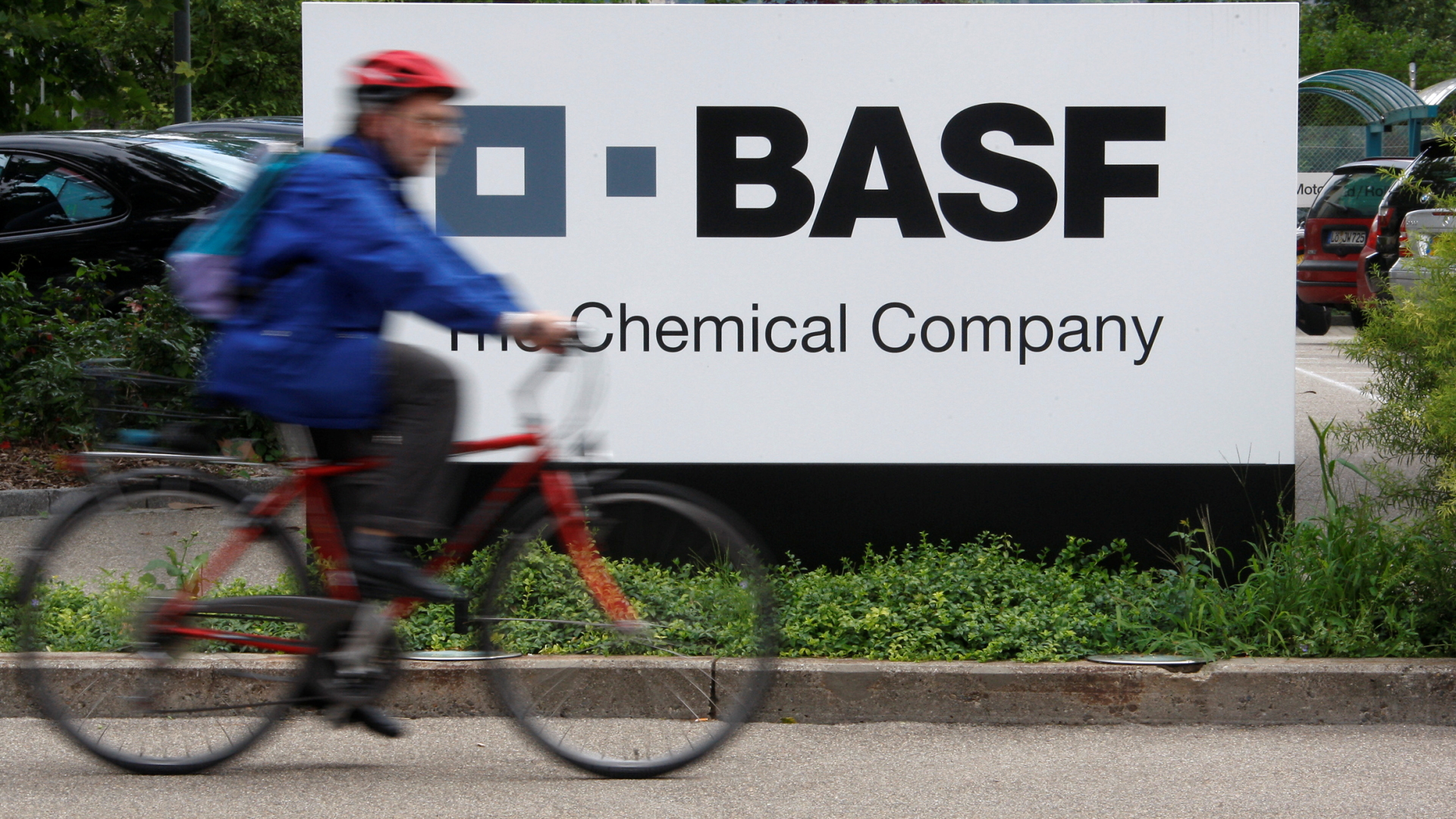 Radfahrer vor BASF-Firmenschild