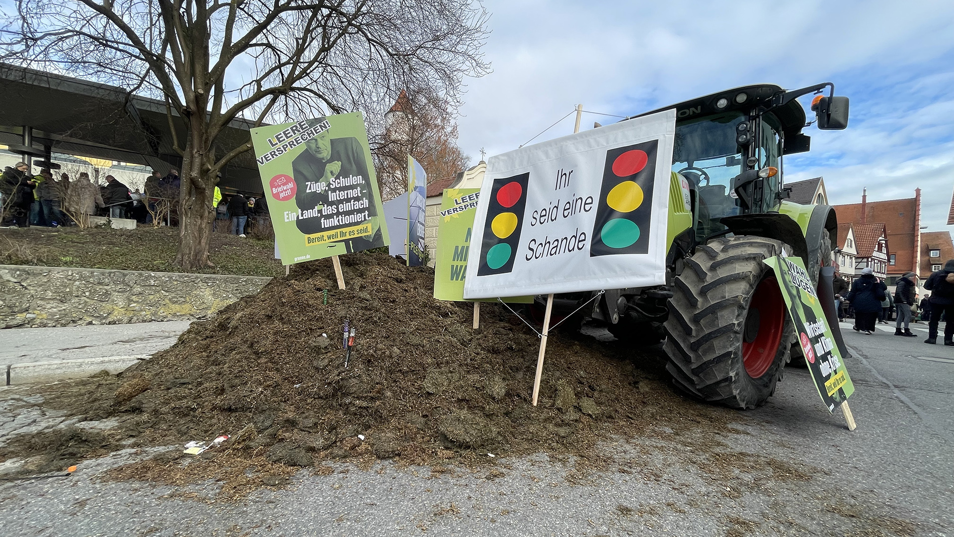 Ein Traktor mit Erdhaufen und Schildern vor der Stadthalle Biberach
