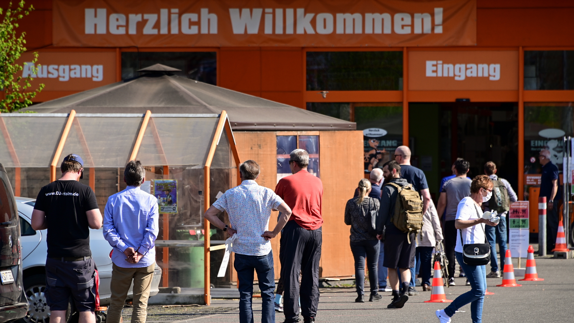 Menschen stehen unter Einhaltung der Abstandsregel vor einem Baumarkt in Kassel an. | dpa