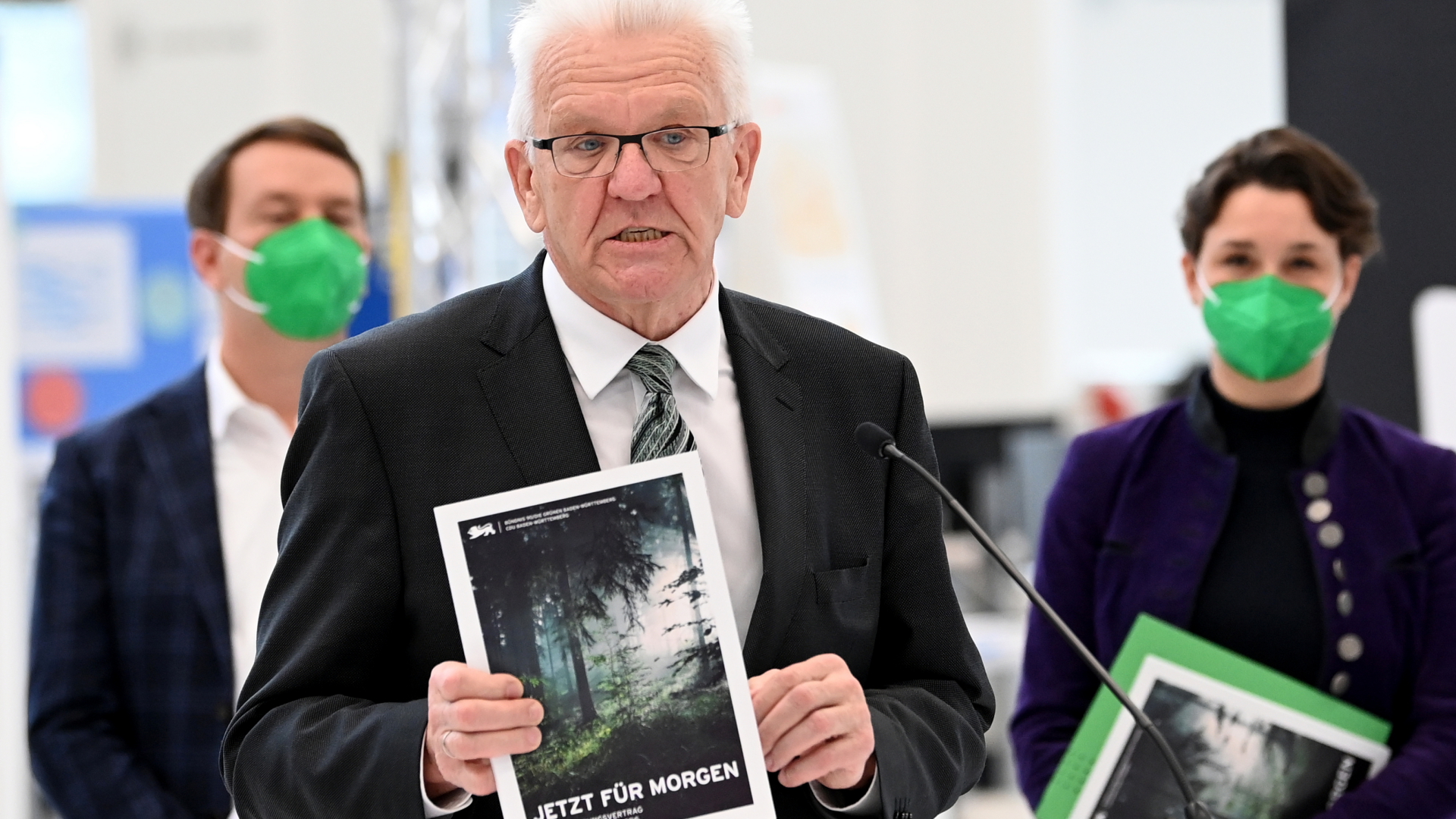 Winfried Kretschmann (M, Bündnis 90/Die Grünen), Ministerpräsident von Baden-Württemberg hälten bei der Präsentation den Koalitionsvertrag der neuen grün-schwarzen Landesregierung in Baden-Württemberg in den Händen.  | dpa