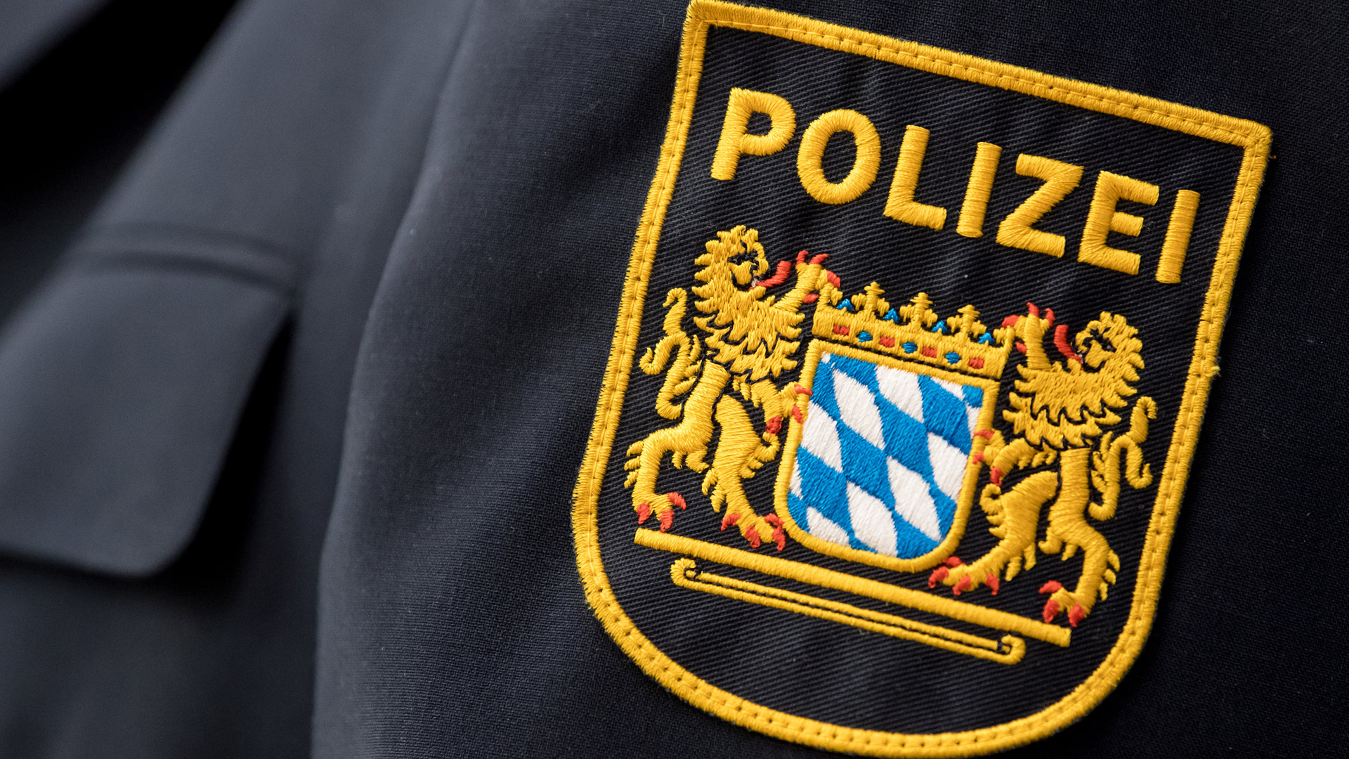 Das Wappen der bayerischen Landespolizei auf dem Ärmel einer Uniform. | dpa