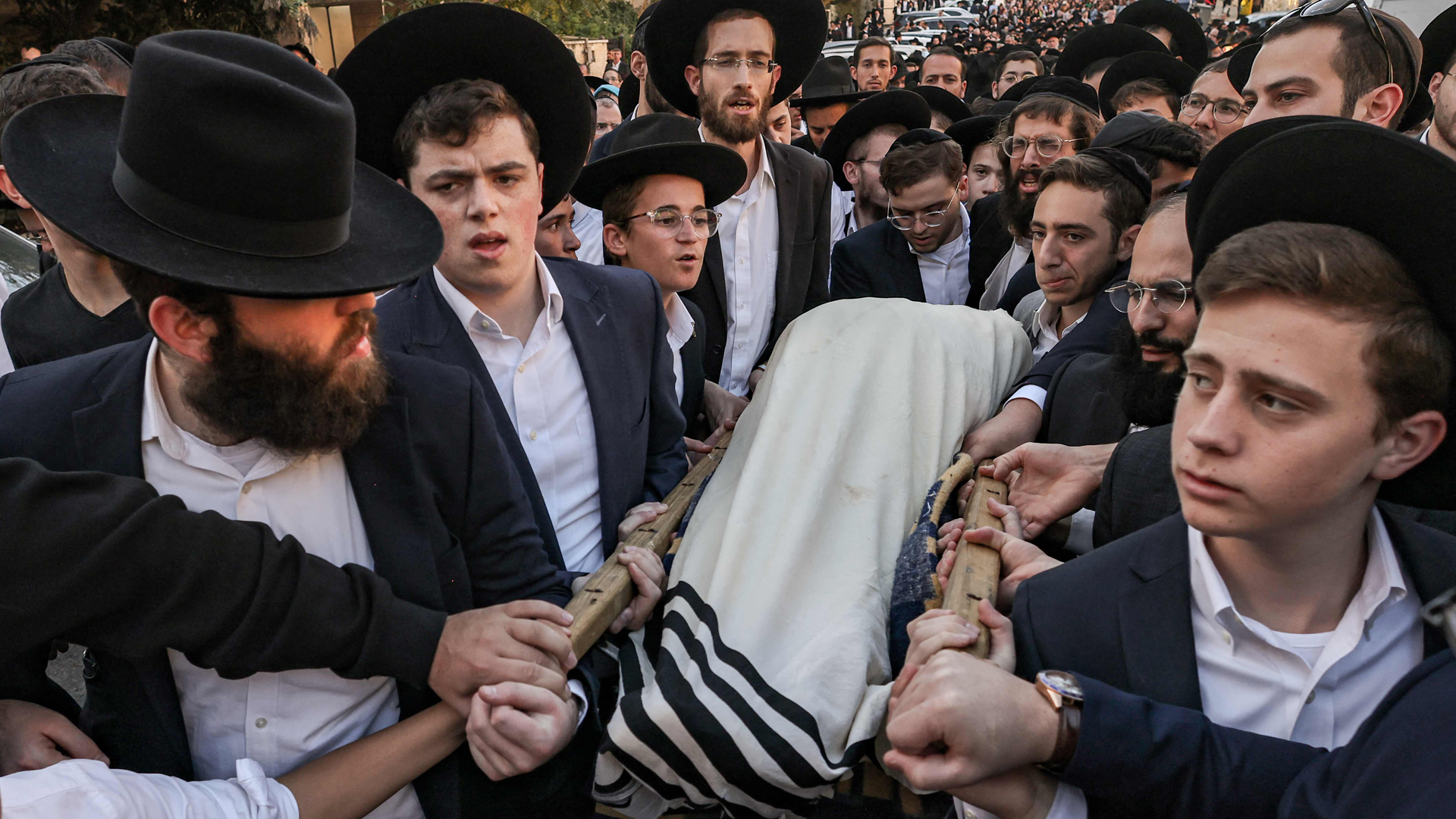 Eine Trauerprozession von ultraorthodoxen Juden trägt den in ein Tuch gewickelten Leichnam eines 16-Jährigen. | AFP