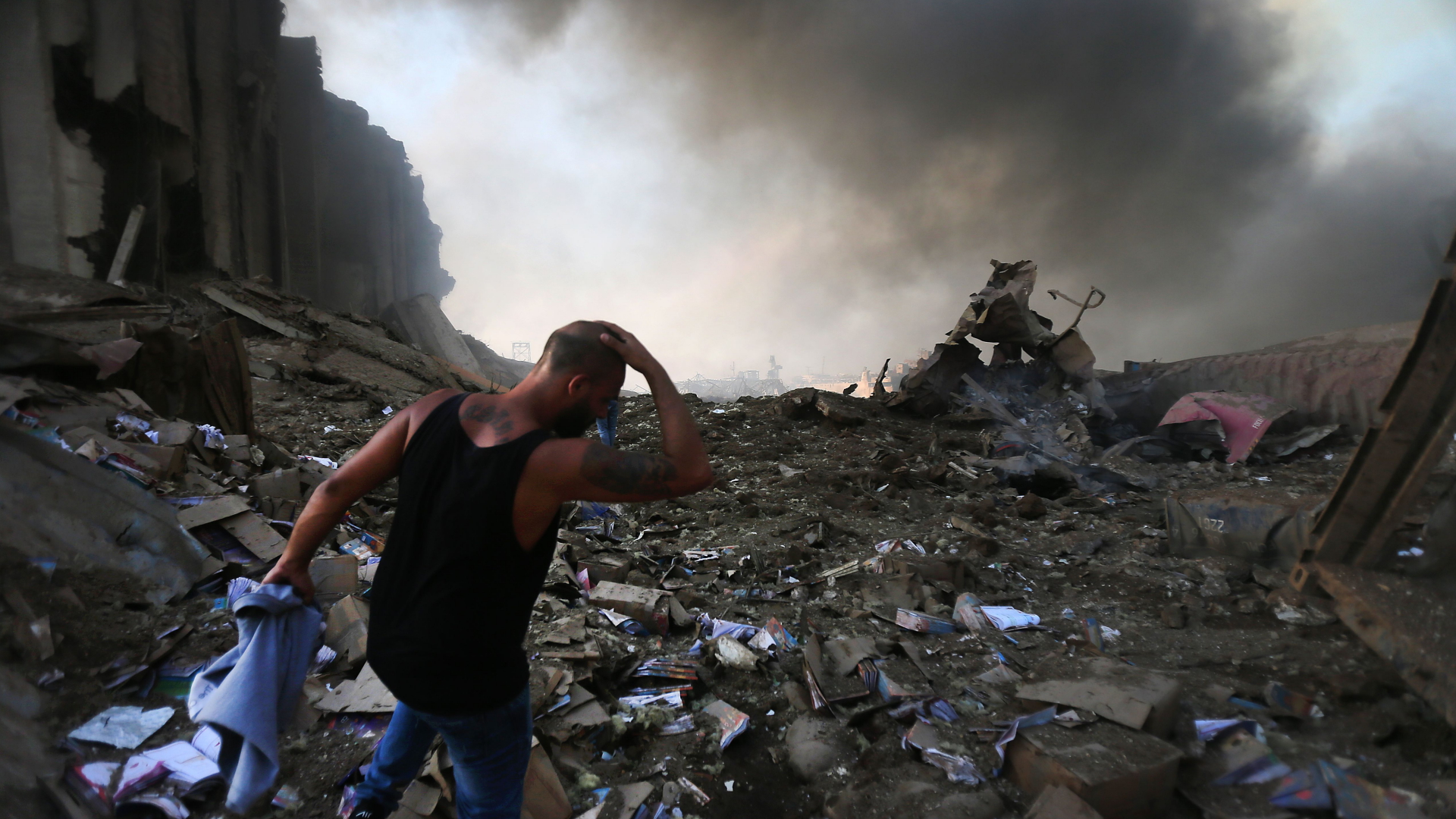 Ein Mann geht am 4. August 2020 entlang der rauchenden Trümmer des explodierten Silos im Beiruter Hafen | AFP