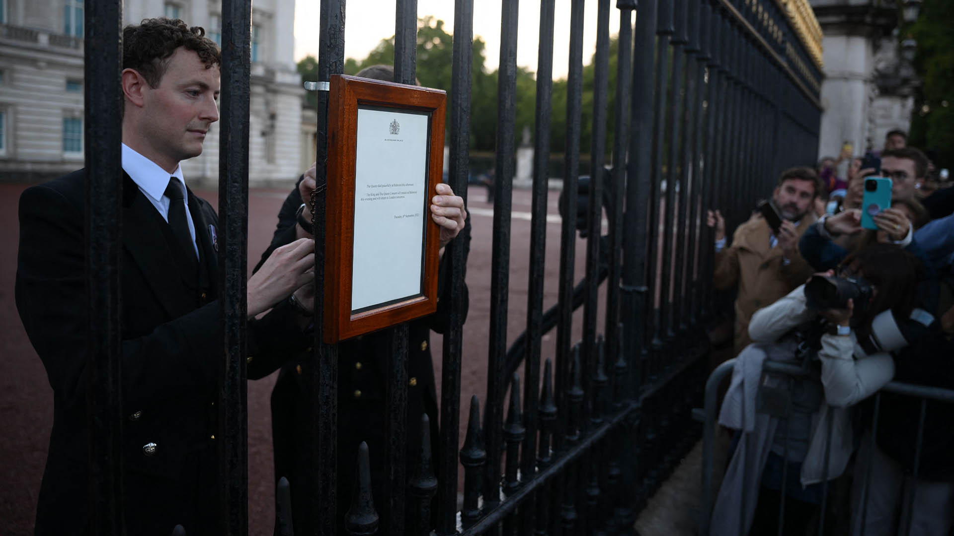 Ein Zettel, der den Tod von Königin Elizabeth II. ankündigt, ist am Geländer vor dem Buckingham Palace im Zentrum Londons angebracht. | AFP