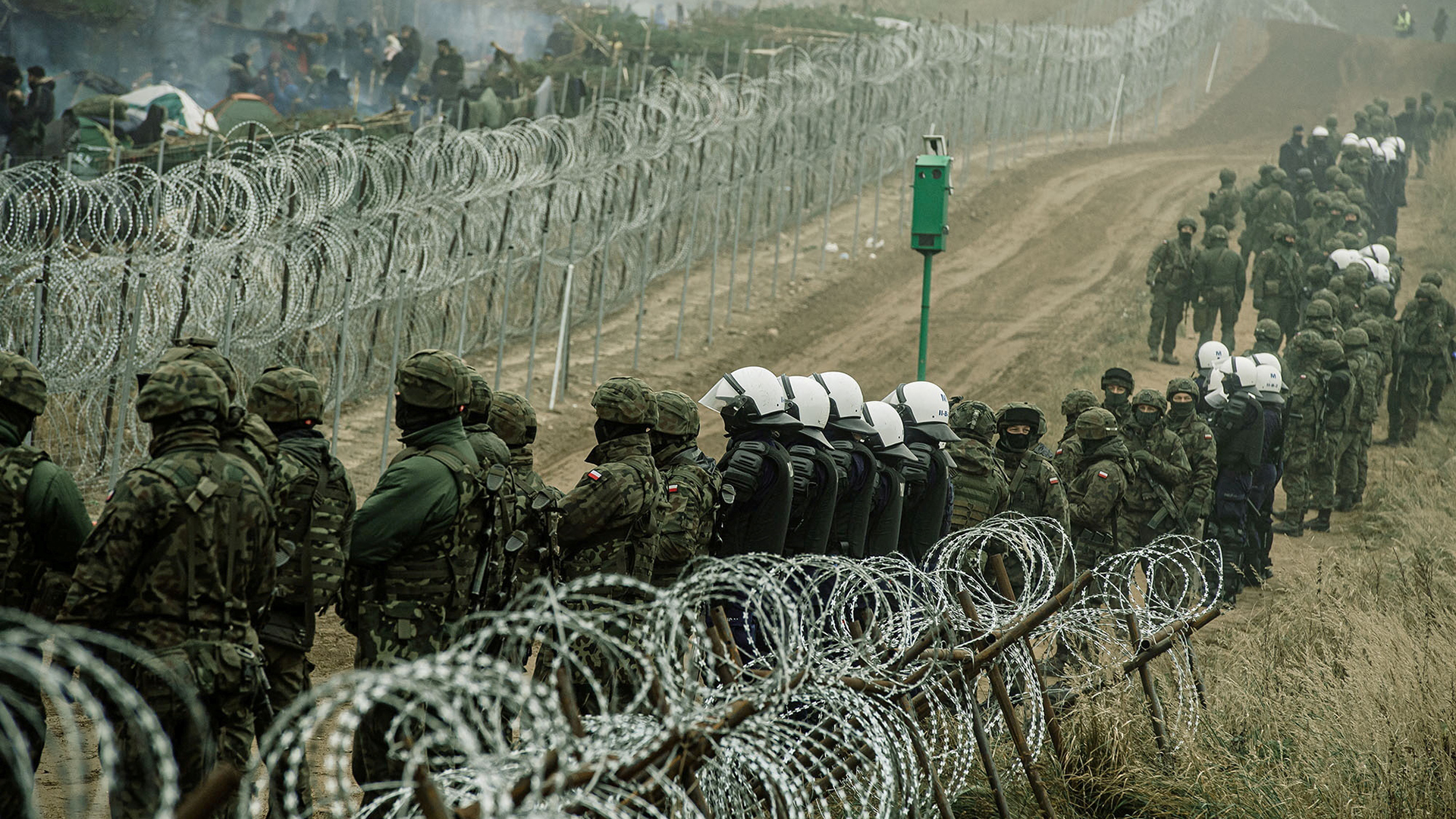 Polnische Soldaten und Polizisten stehen an der polnisch-belarusischen Grenze. | via REUTERS