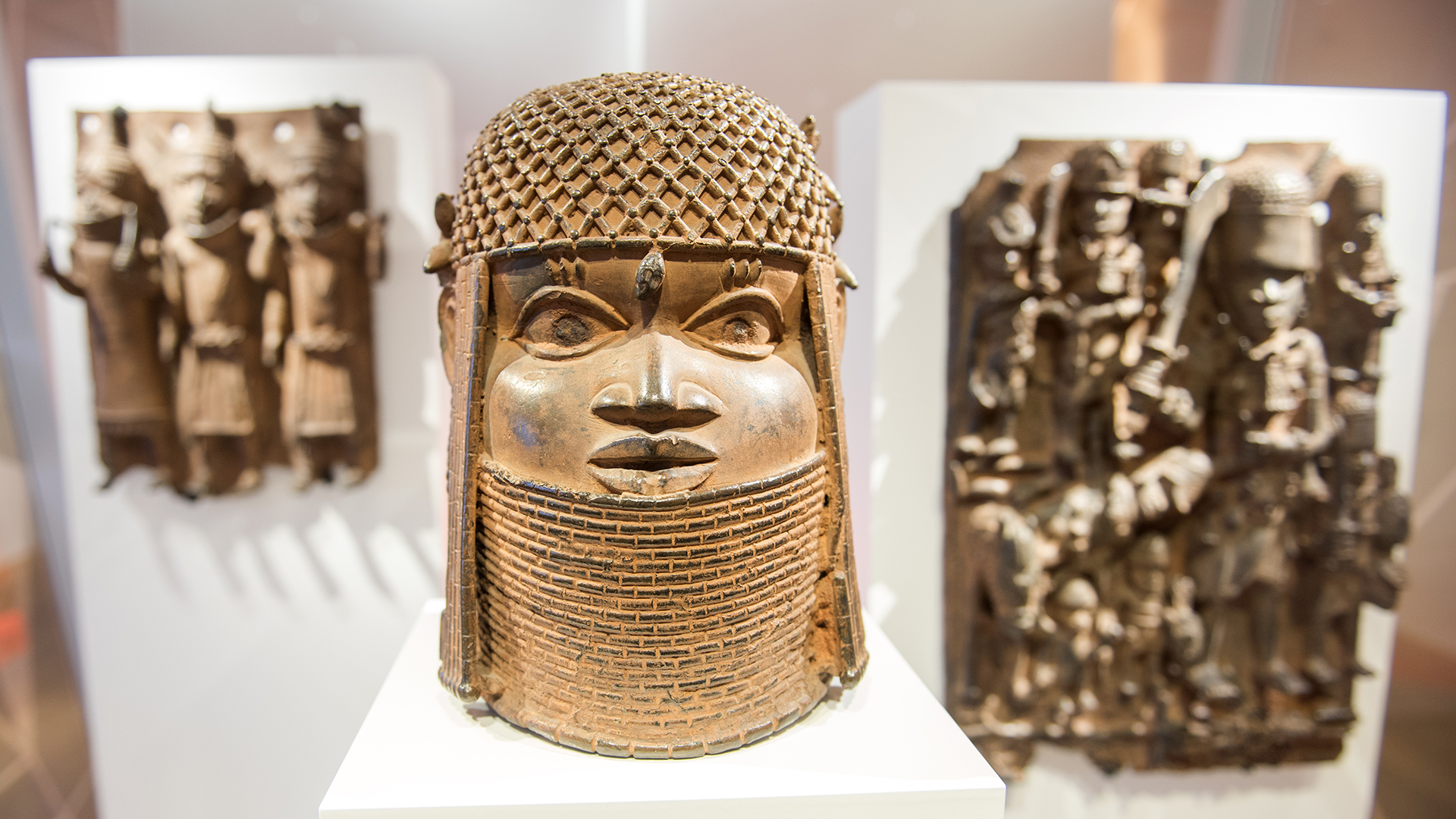Drei Raubkunst-Bronzen aus dem Benin in Westafrika sind im Hamburger Museum für Kunst und Gewerbe in einer Vitrine ausgestellt. | dpa