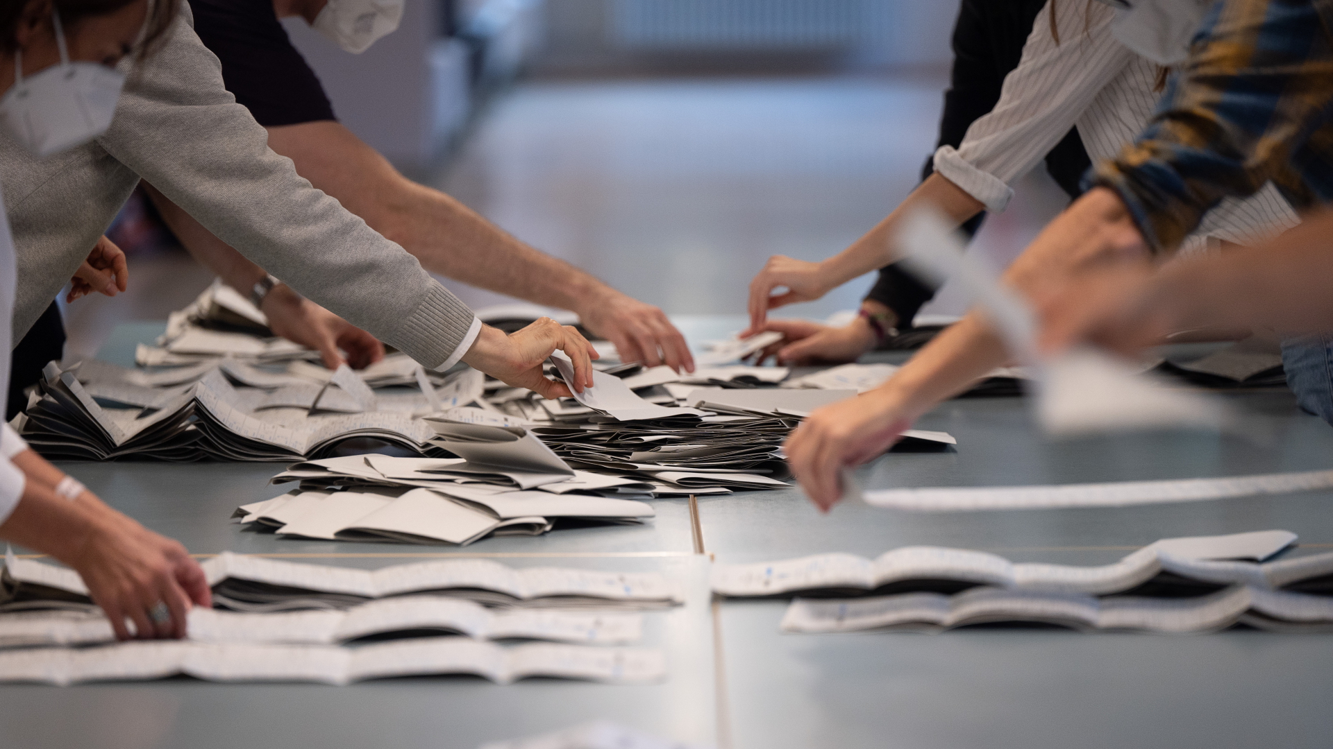 Wahlhelfer und Wahlhelferinnen zählen in einem Berliner Wahllokal Stimmzettel für die Bundestagswahl 2021