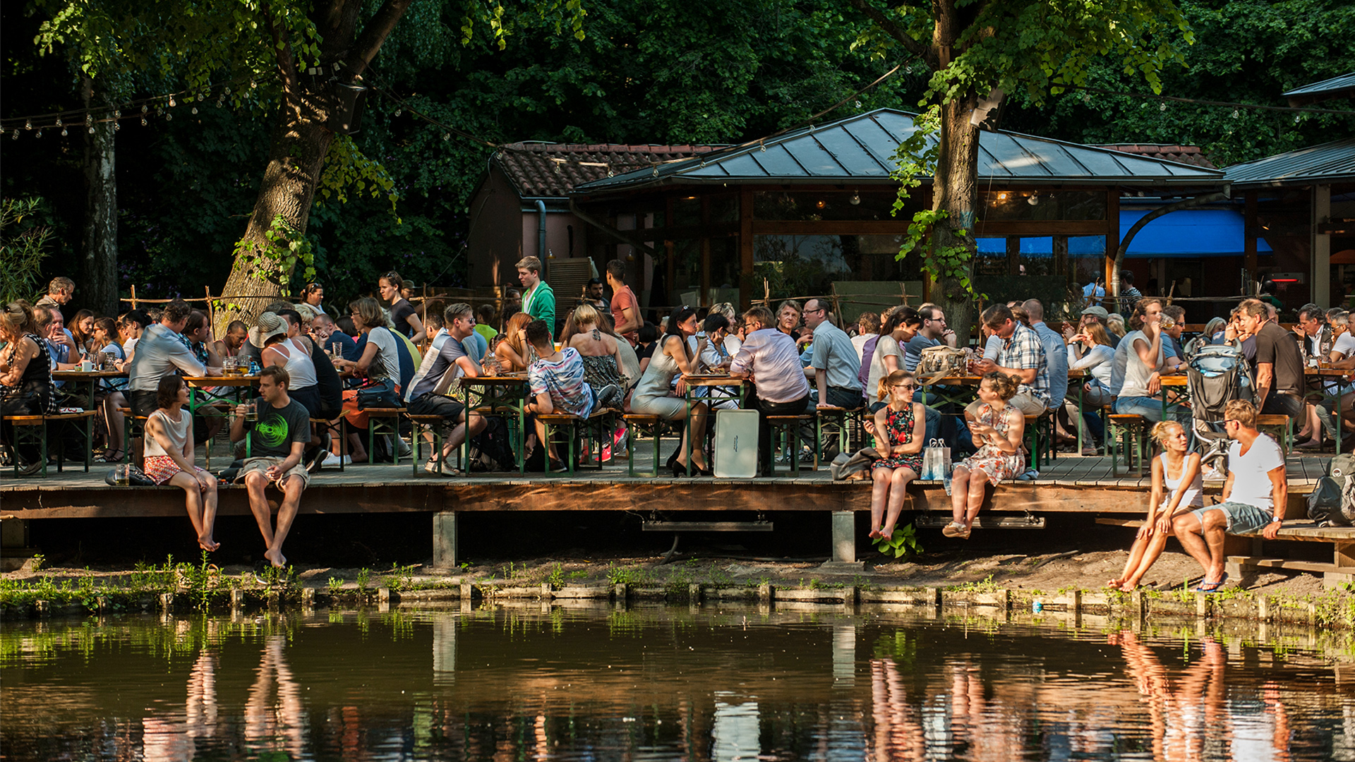 Zahlreiche Menschen sitzen in Berlin am Abend im Biergarten Neuer See im Tiergarten.