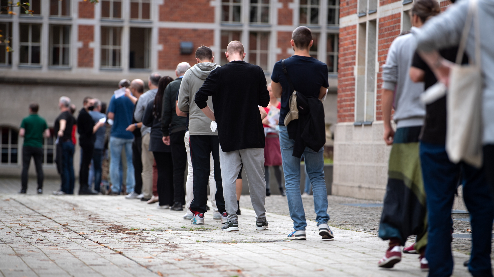 Menschen stehen bei der Wahl des Berliner Abgeordnetenhauses vor einem Wahllokal Schlange. | dpa