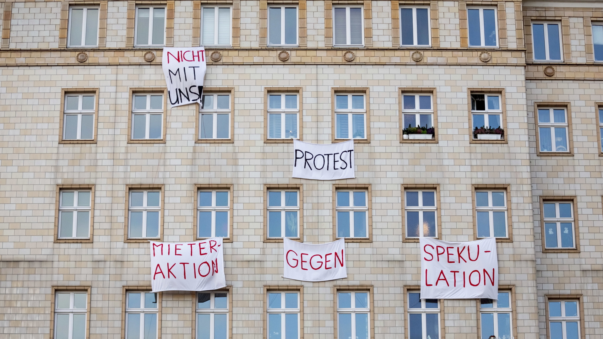 Protest-Plakate hängen an einer Gebäudefassade in der Karl-Marx-Allee | dpa
