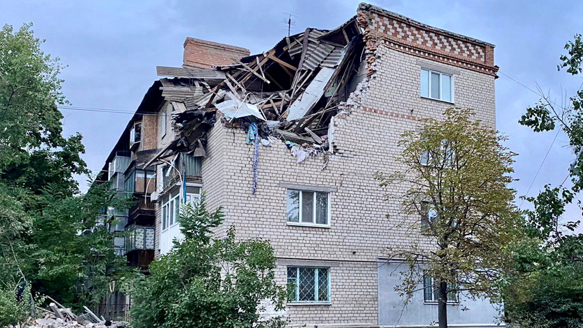 Ein durch einen russischen Militärschlag beschädigtes Wohngebäude in der Stadt Nikopol | via REUTERS