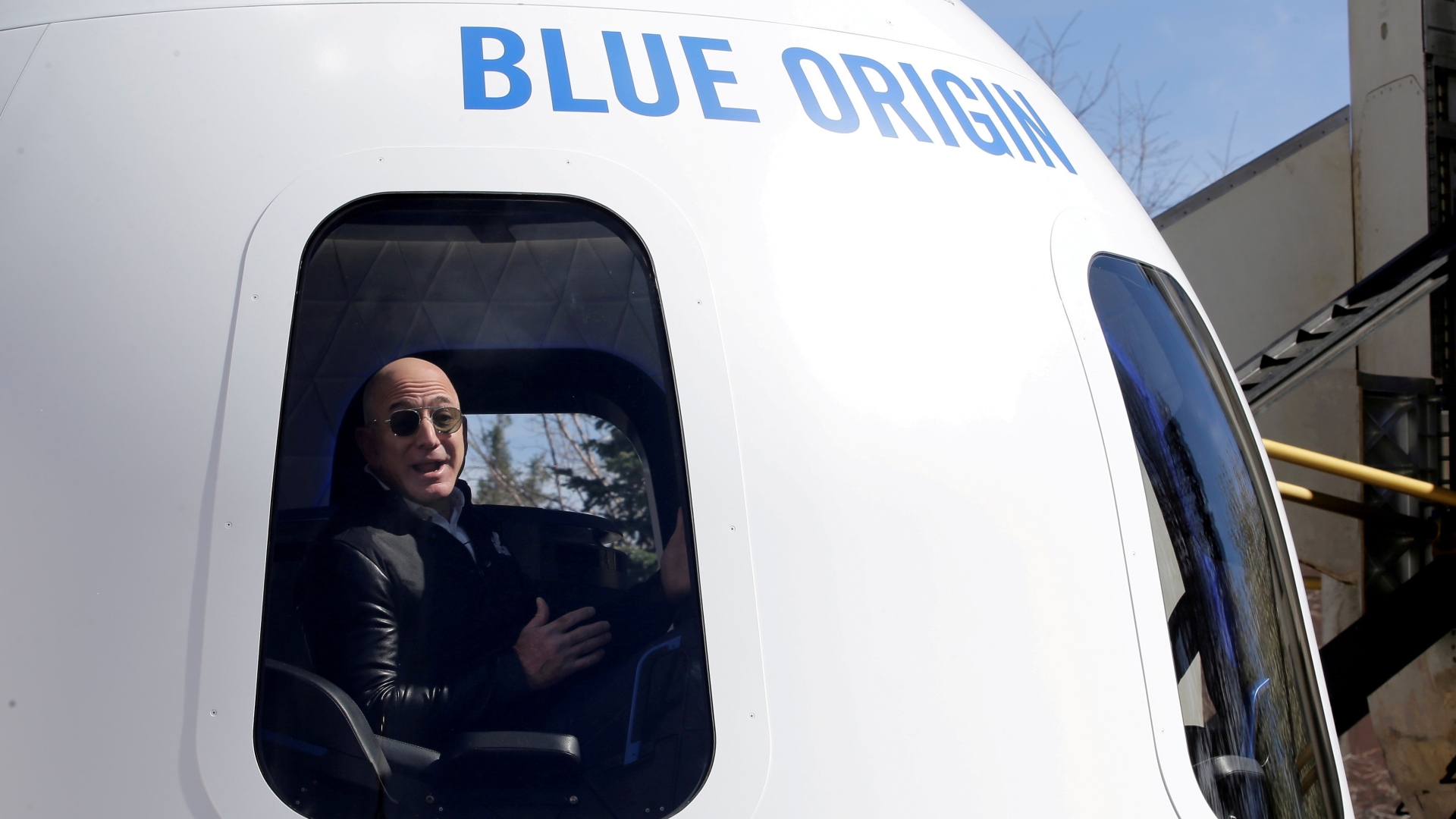 Amazon-Gründer Jeff Bezos sitzt begeistert in der Weltraumkapsel von Blue Origin. | REUTERS