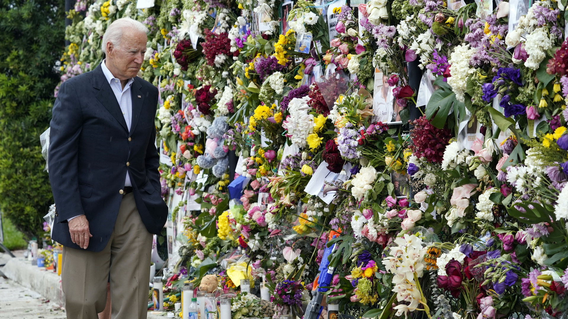 Joe Biden, Präsident der USA, besucht eine mit Blumen und Fotos der Vermissten bedeckte Gedenkwand in der Nähe des teilweise eingestürzten Champlain Towers South Condo Building nahe Miami. | dpa
