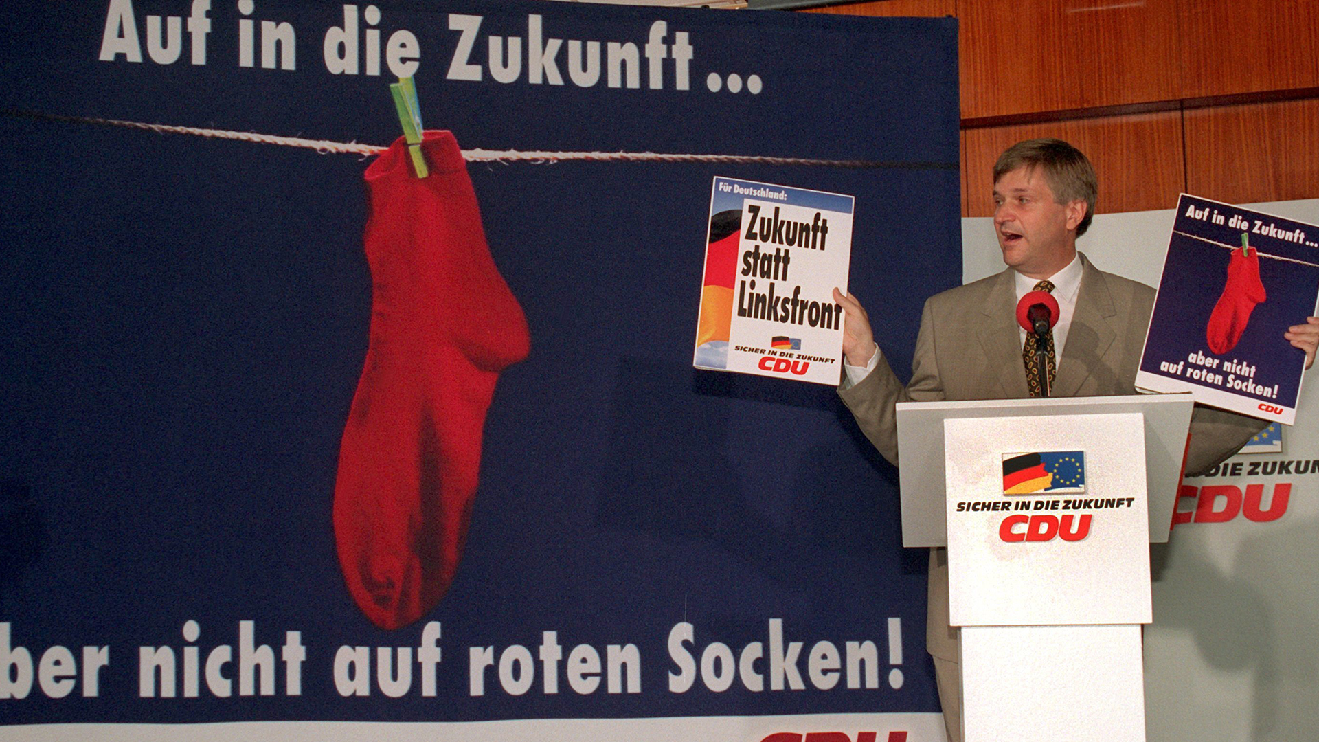 CDU-Generalsekretär Peter Hintze stellt am 18.7.1994 in Bonn mit dem Wahlplakat "Auf in die Zukunft ... aber nicht auf roten Socken" eine Aktion gegen die neue deutsche "Linksfront" vor. | picture-alliance/ dpa