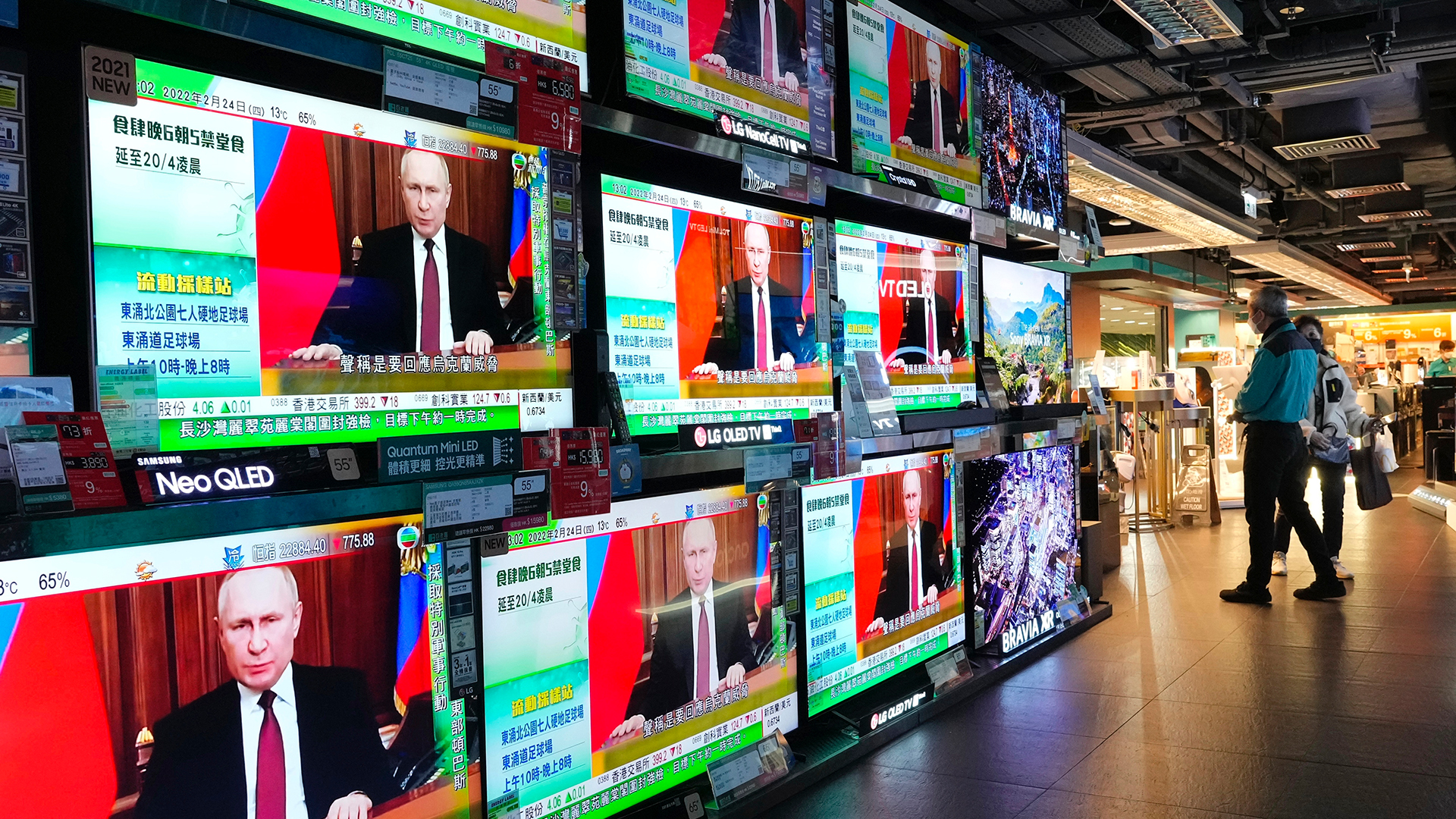 Fernsehbildschirme zeigen eine Nachrichtensendung auf der der russische Präsident Putin spricht. | picture alliance/dpa/AP