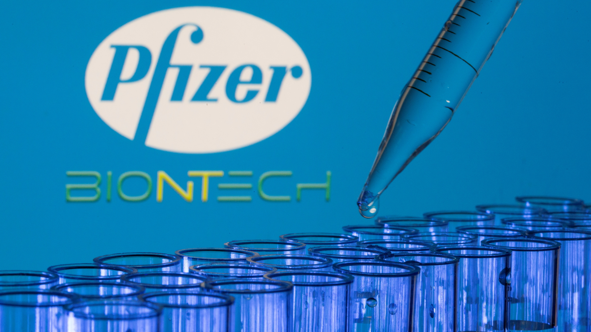 Blaue Reagenzgläser vor Schriftzug von Pfizer/Biontech | REUTERS