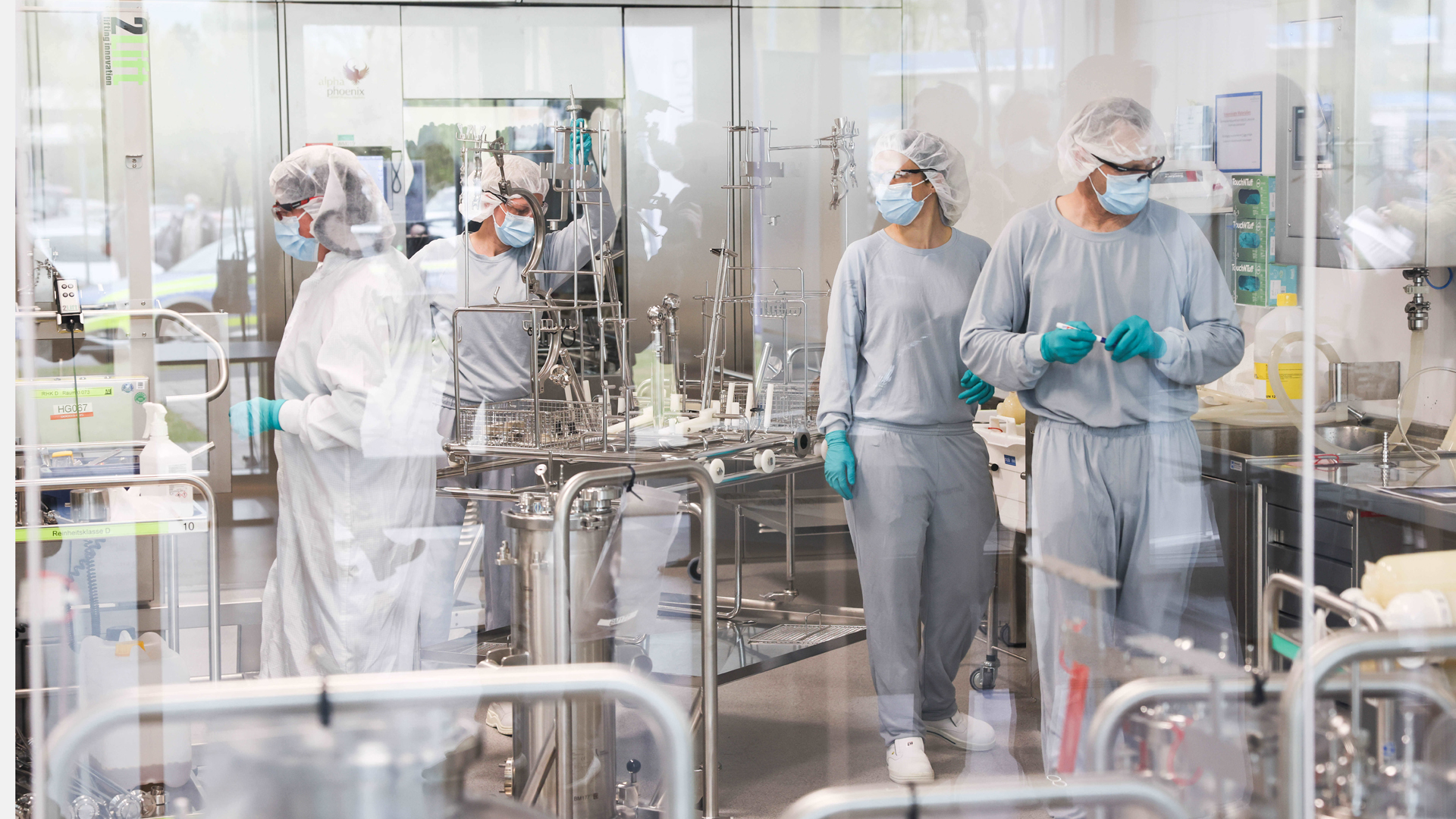 Mitarbeitende in Reinraumkleidung arbeiten in der Produktion des Impfstoffes Comirnaty von BioNTech/Pfizer.