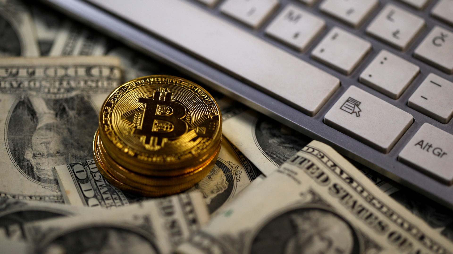 Bitcoin-Münzen auf Dollarscheinen vor Computertastatur | REUTERS