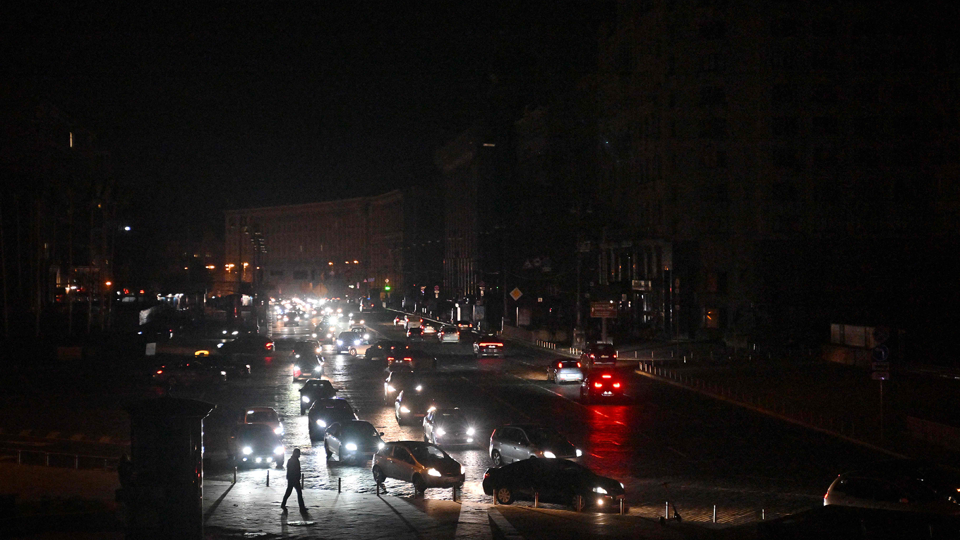 Ein Fußgänger inmitten von Autos während eines Stromausfalls in Teilen der ukrainischen Hauptstadt in Chreschtschatyk, der zentralen Straße von Kiew. | AFP