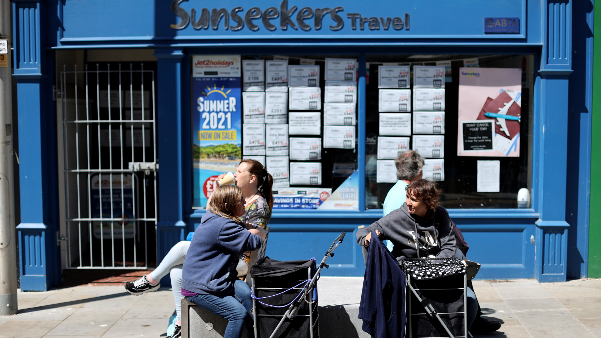 Menschen in Blackpool genießen vor einem Reisebüro die Sonne | REUTERS