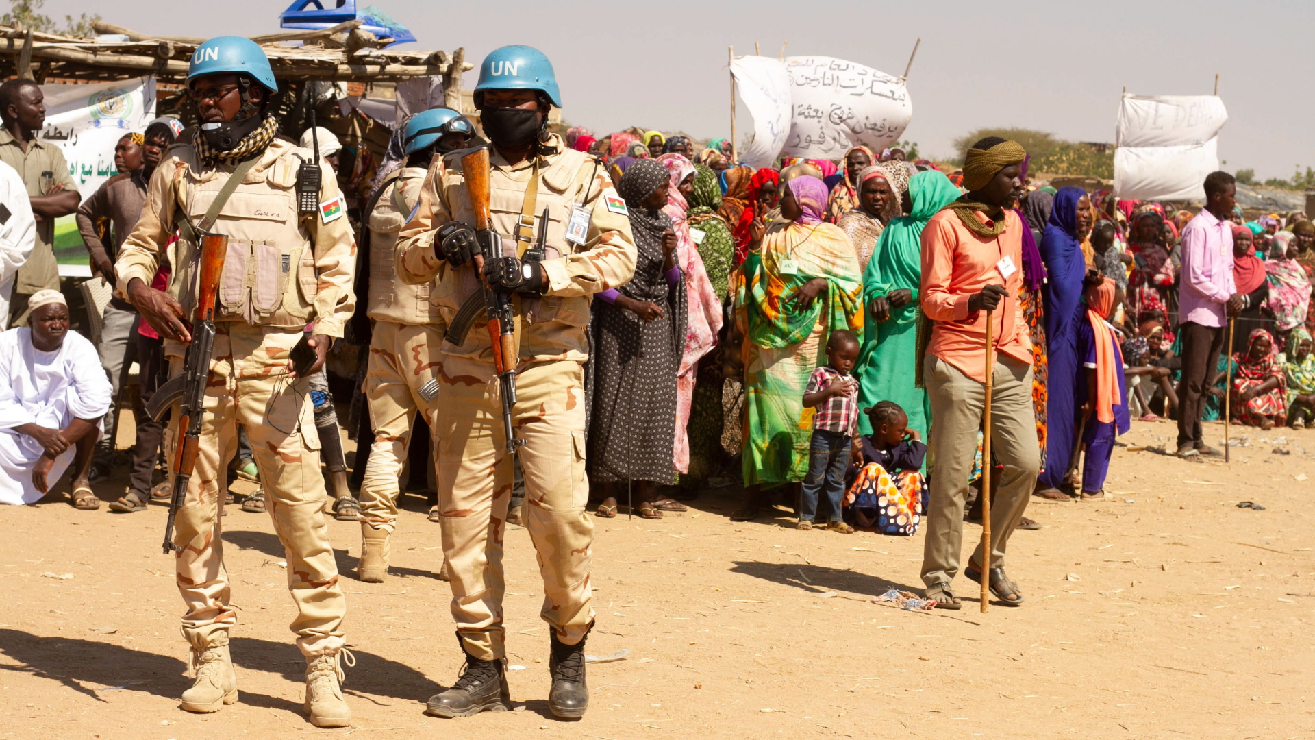 Soldaten der Unamid-Mission in Darfur beobachten Menschen, die gegen das Ende der Mission protestieren.| Bildquelle: AFP