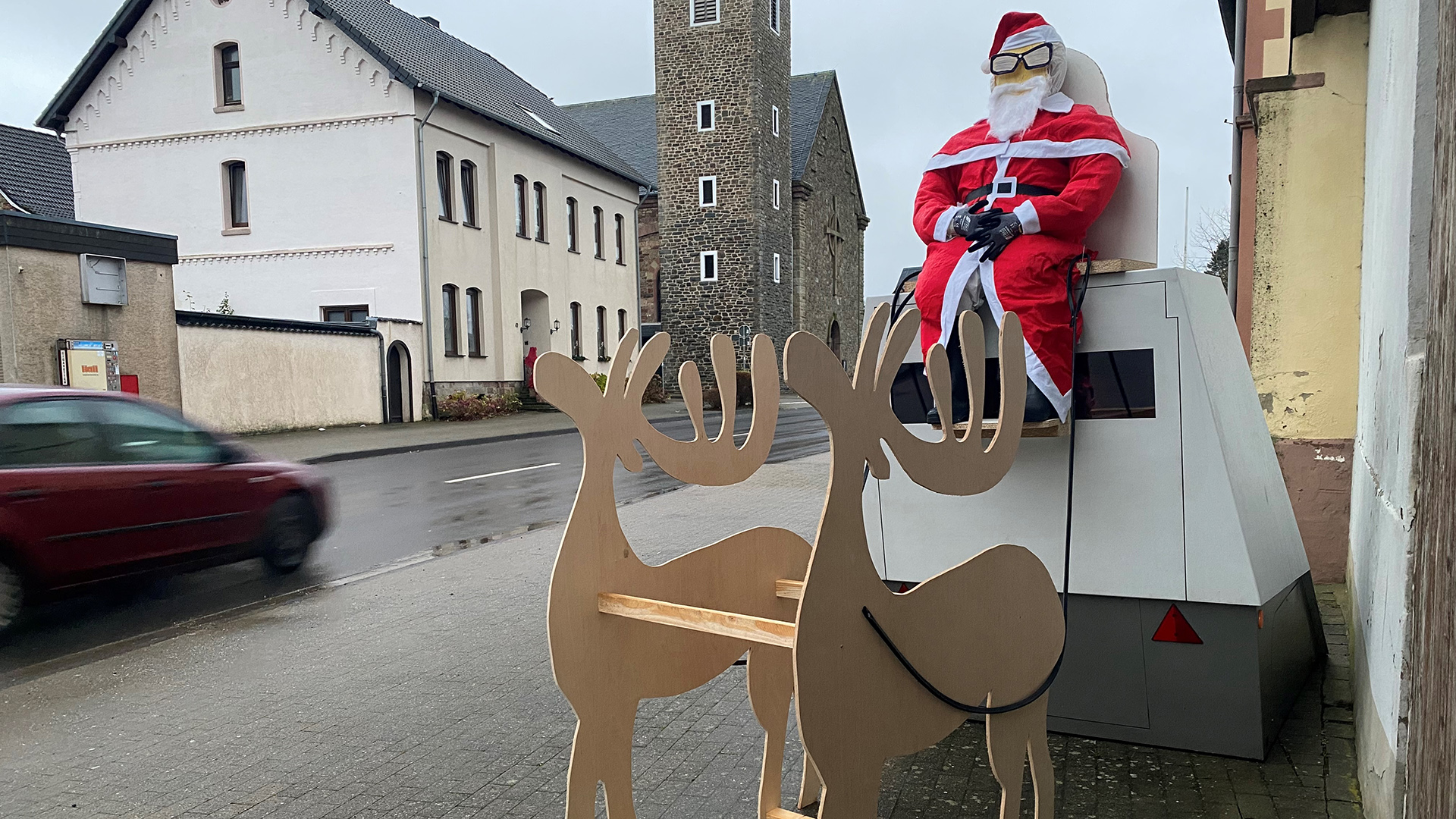 Eine mobile Radarfalle dekoriert mit einem Weihnachtsmann und einem Schlitten steht in Hürtgenwald, Nordrhein-Westfalen.  | dpa
