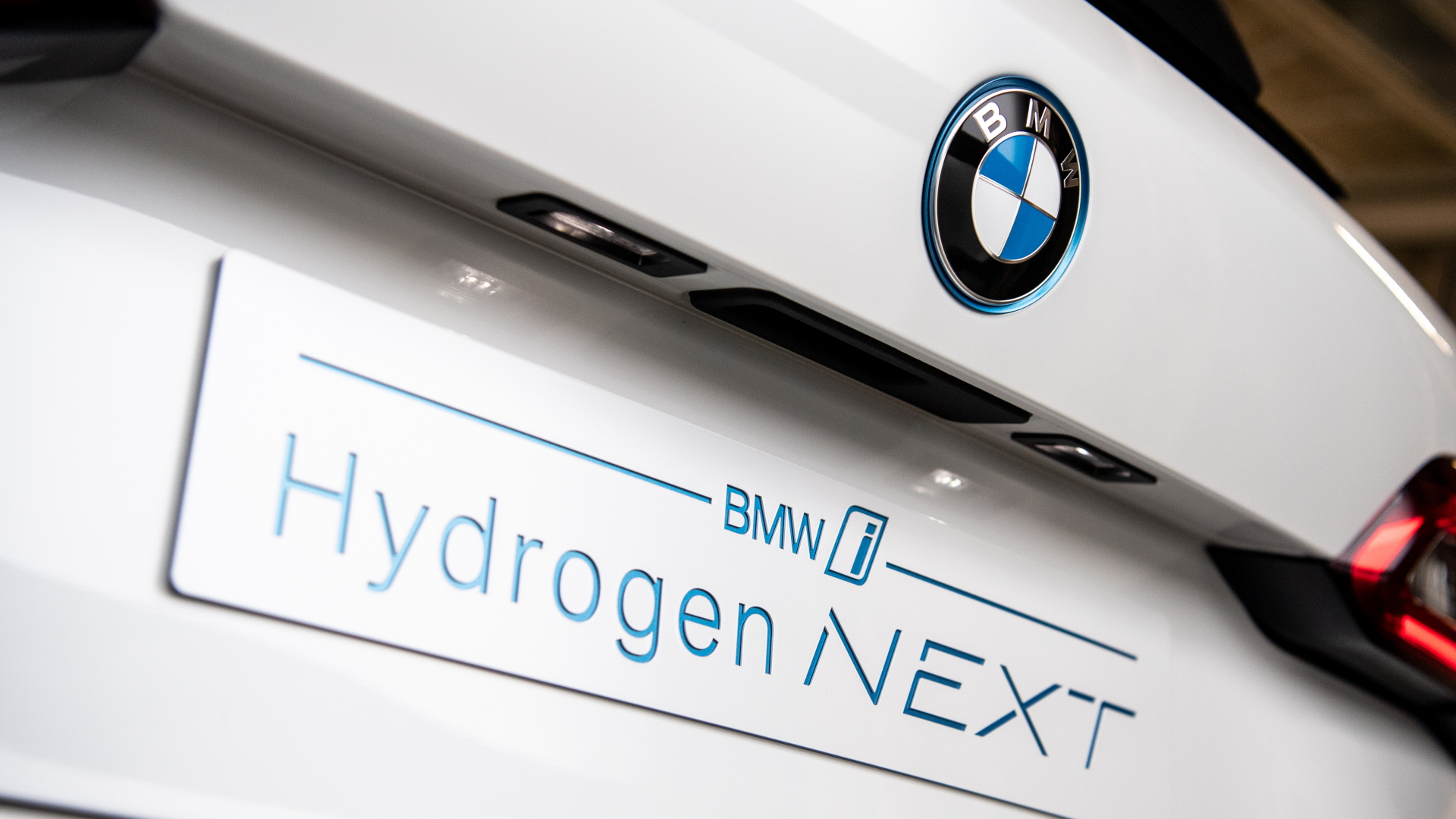Der Schriftzug "BMW i - Hydrogen Next" an der Front eines mit einem Wasserstoffantrieb ausgestatteten BMW X5 | dpa