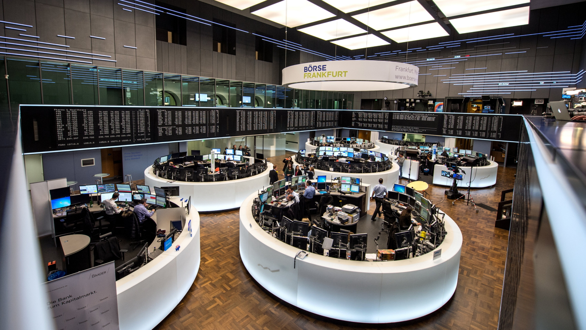 Menschen arbeiten auf dem Börsenparkett in Frankfurt. | dpa