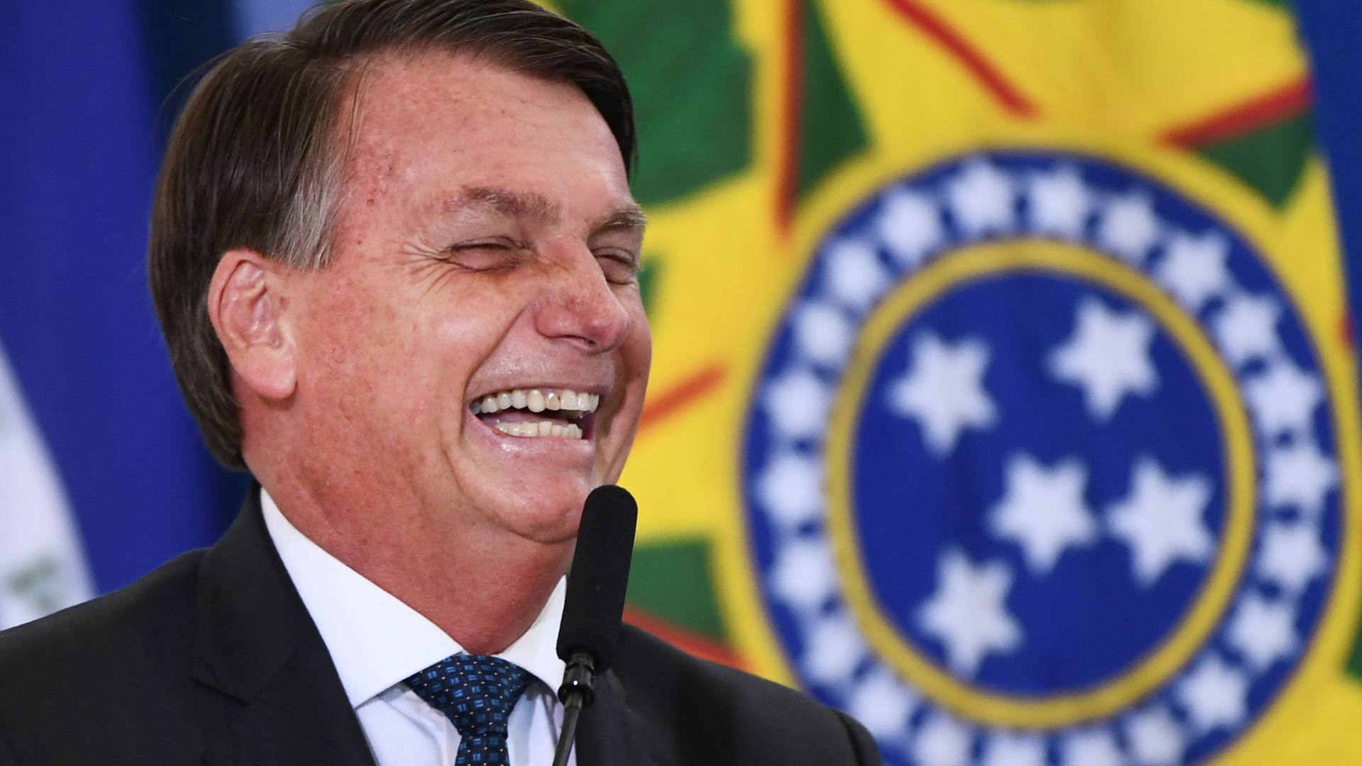 Der brasilianische Präsident Jair Bolsonaro lacht. | AFP