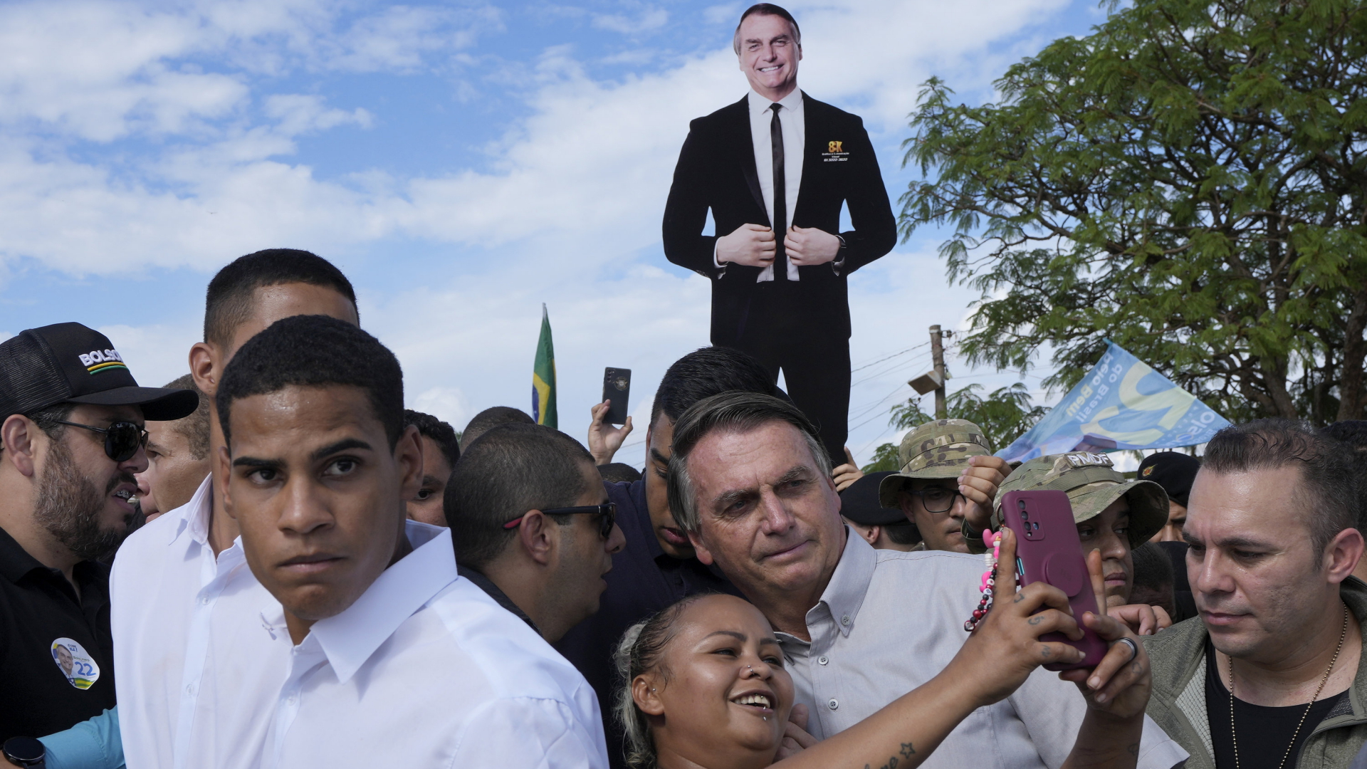Jair Bolsonaro posiert mit einer Anhängerin für ein Selfie. | AP