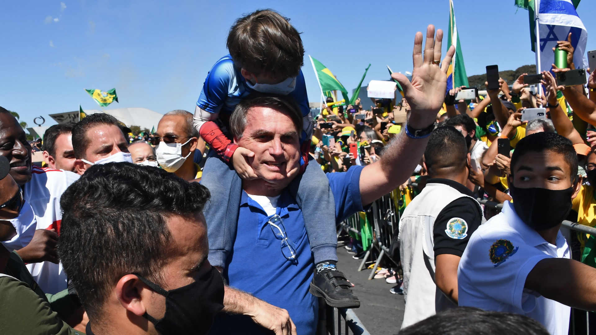 Brasiliens Präsident Bolsonaro trägt bei einer Kundgebung im Mai 2020 das Kind eines Unterstützers auf den Schultern. | AFP