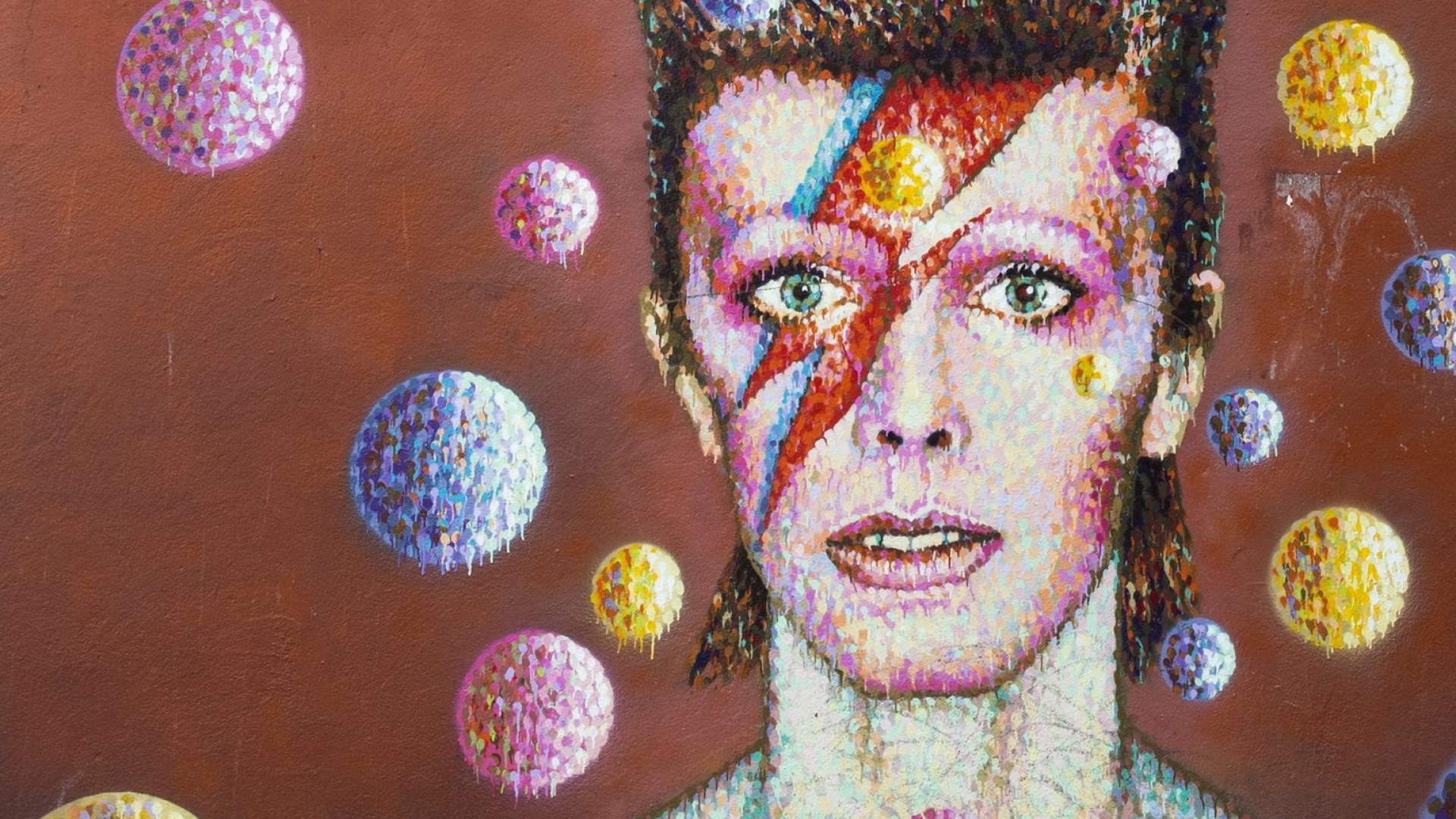 Ein riesiges buntes Wand-Portrait, das David Bowie zeigt | dpa