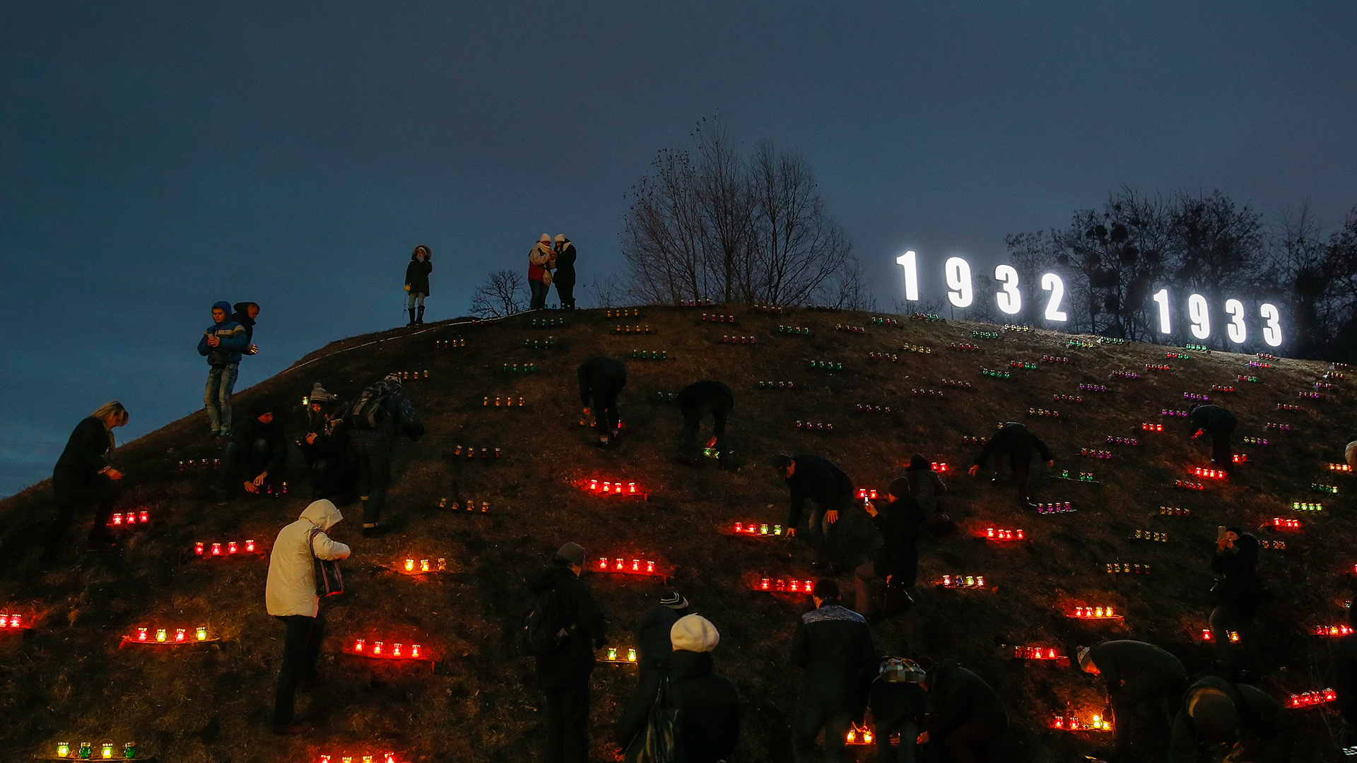 Ukrainer zünden am Denkmal der Großen Hungersnot Kerzen an.