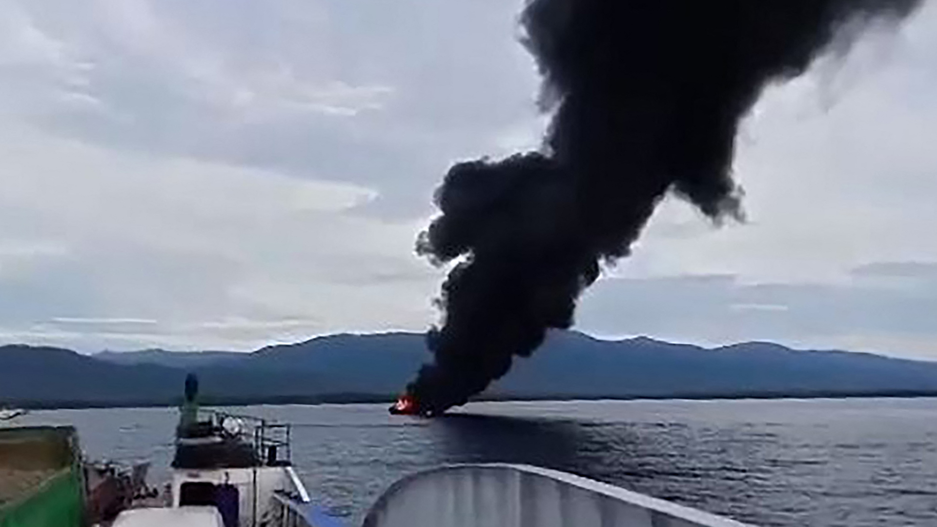 Eine schwarze Rauchwolke steigt über dem brennenden Schiff auf. | AFP