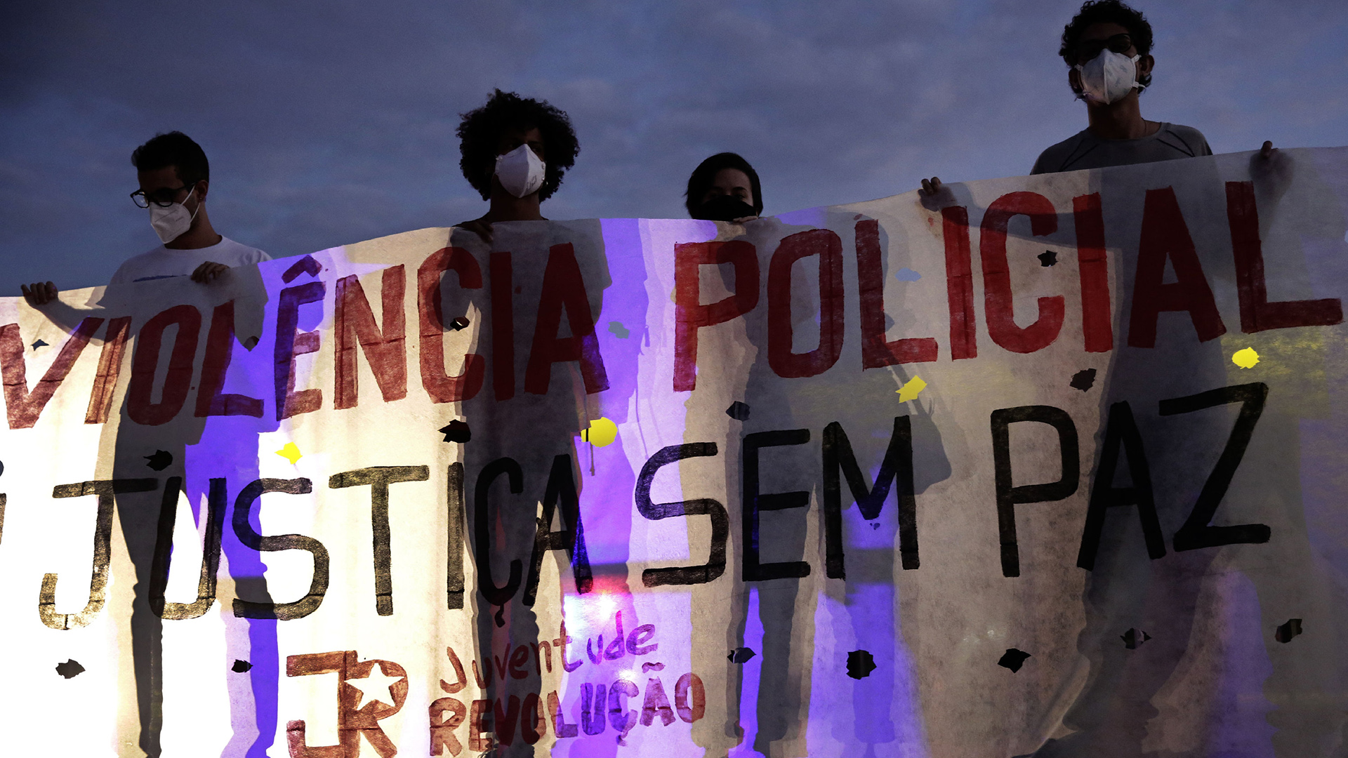 Junge Demonstranten in Rio de Janeiro halten ein Plakat mit der Aufschrift "Stopp die Poizeigewalt! Frieden und Gerechtigkeit" | AP