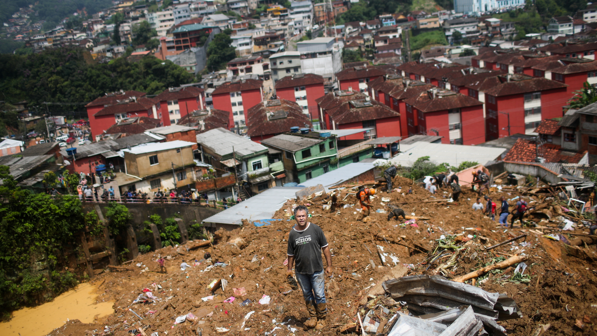 Menschen stehen auf Schlamm und Trümmern nach einem Erdrutsch | REUTERS