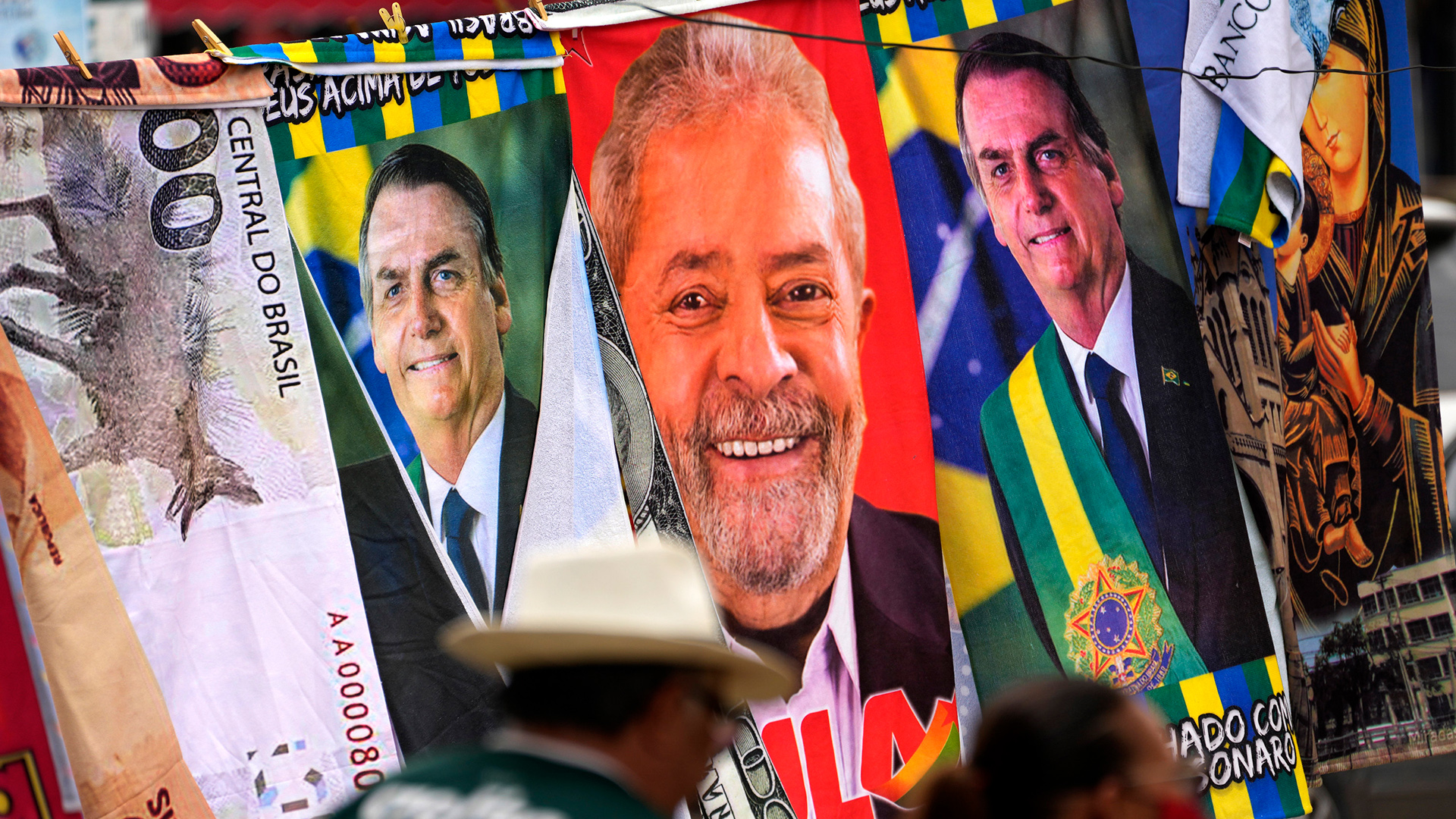 Auf einer Leine eines Händlers hängen Handtücher mit den Kandidaten bei der Wahl in Brasilien, Jair Bolsonaro und Luiz Inacio Lula da Silva. | AP