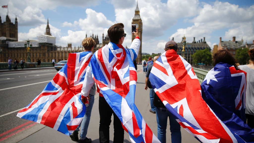 Menschen mit Großbritannien-Flaggen gehen auf das britische Parlament in London zu.