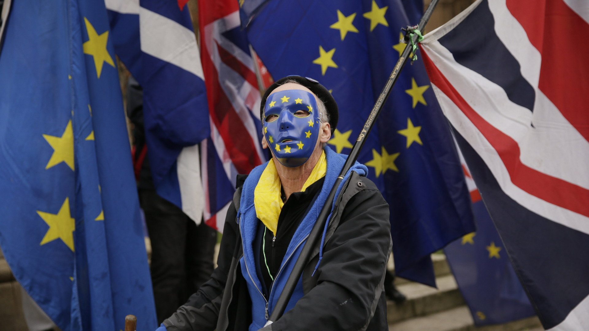 Ein Brexit-Gegner läuft in London auf einer Demonstration mit. Er trägt eine blaue Maske mit den Sternen der EU. | dpa
