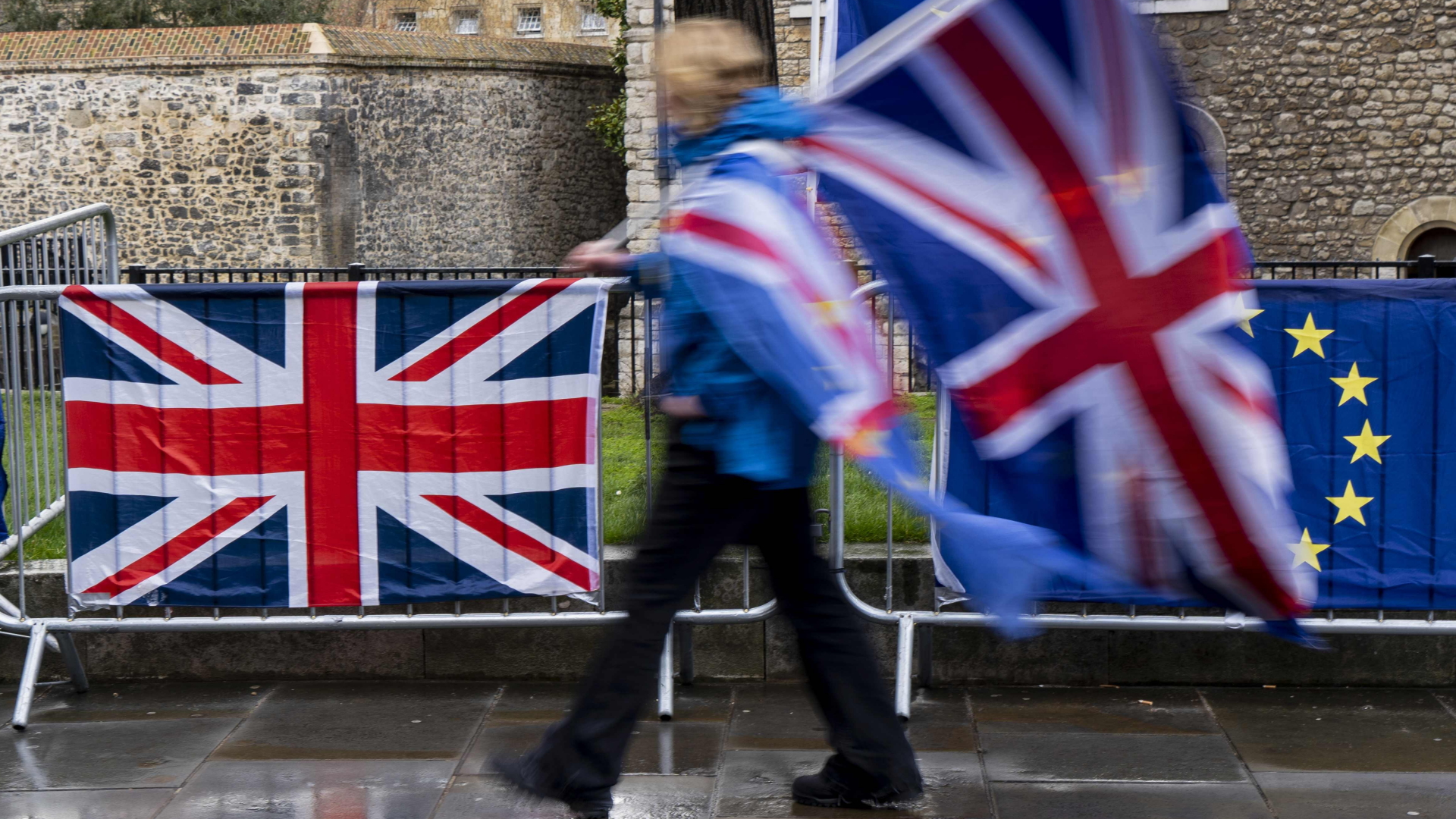 Ein Demonstrant zwischen den Flaggen der EU und Großbritannien | AFP