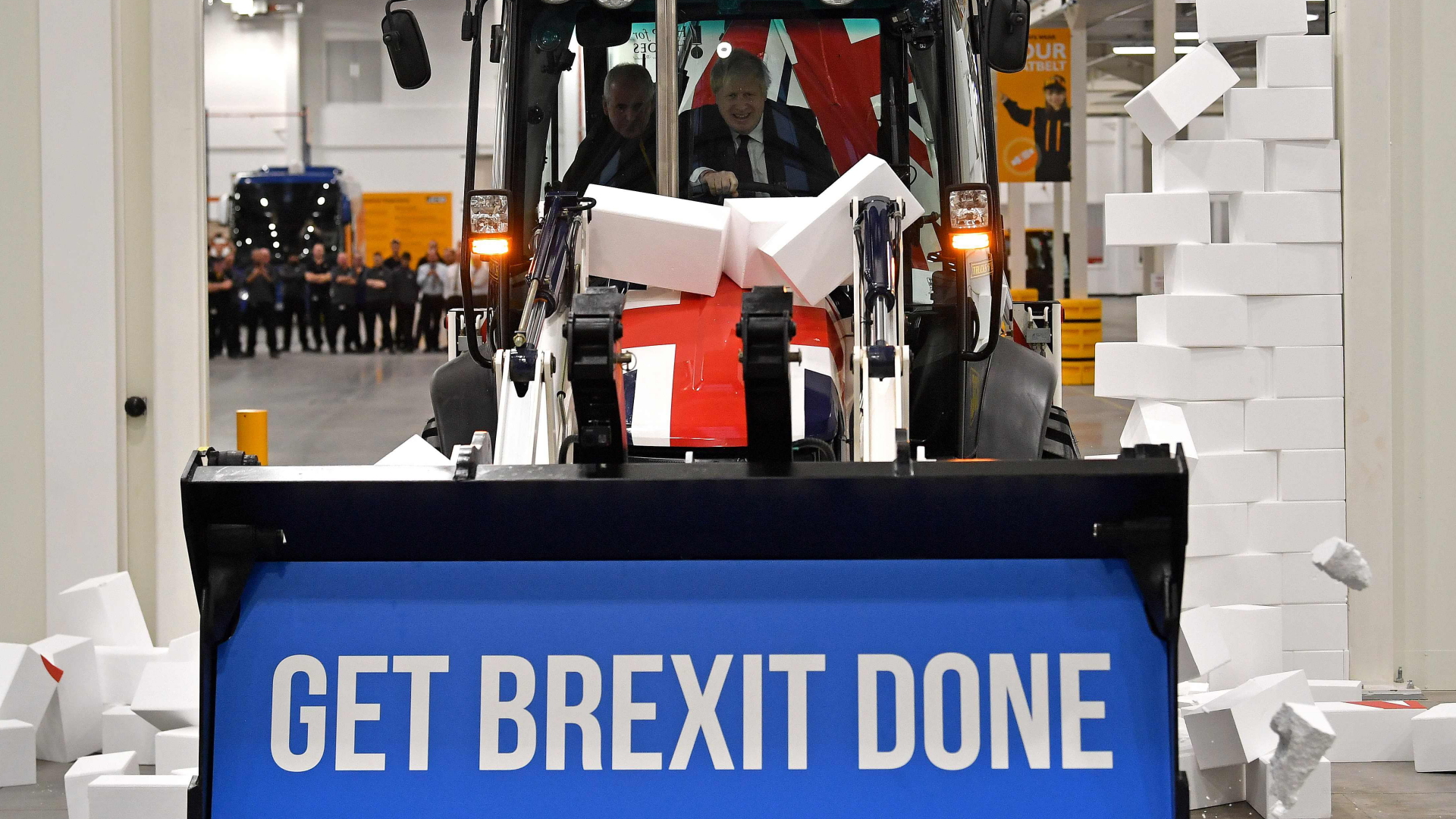 Während des Wahlkampfs im Dezember 2019 fährt Boris Johnson mit einem Bagger mit der Aufschrift "Get Brexit done" symbolisch durch eine Styropor-Mauer