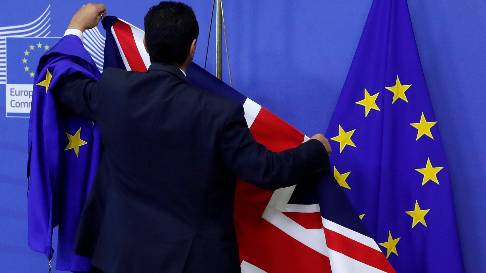 Ein Mitarbeiter in Brüssel arrangiert die EU- und die GB-Flaggen | Bildquelle: REUTERS